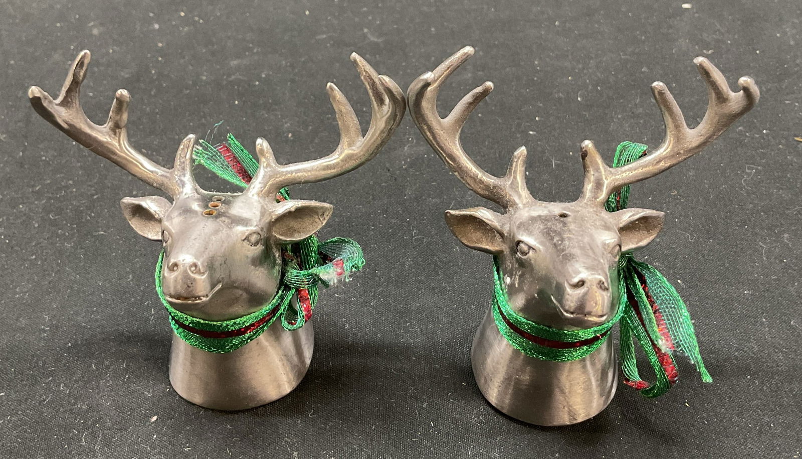 Pair Vintage Metal Reindeer Salt & Pepper Shakers: Vintage metal reindeer salt and pepper shakers. Metal, possibly pewter. Reindeer shape with detailed features and textures. Accented with green and red ribbon. Measures ht approx 3 inches base