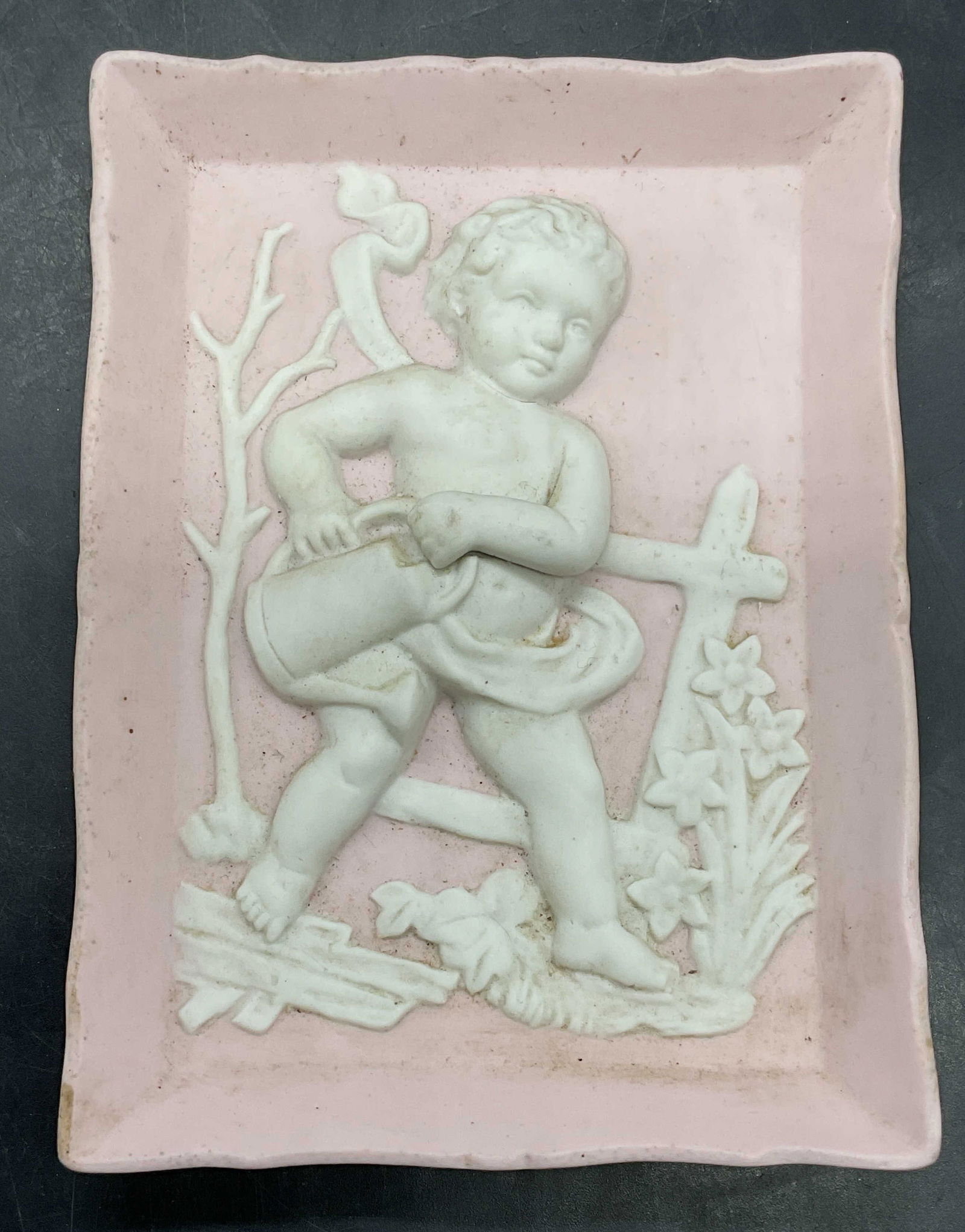 Pink & White Porcelain Cherub Relief Plaque: Pink and white porcelain cherub relief plaque. Measures approx 5 x 3.75 inches. Some scratching. Cherub plaque, porcelain cherub plaque, wall plaque, wall decor, wall accessories, home decor, home acc