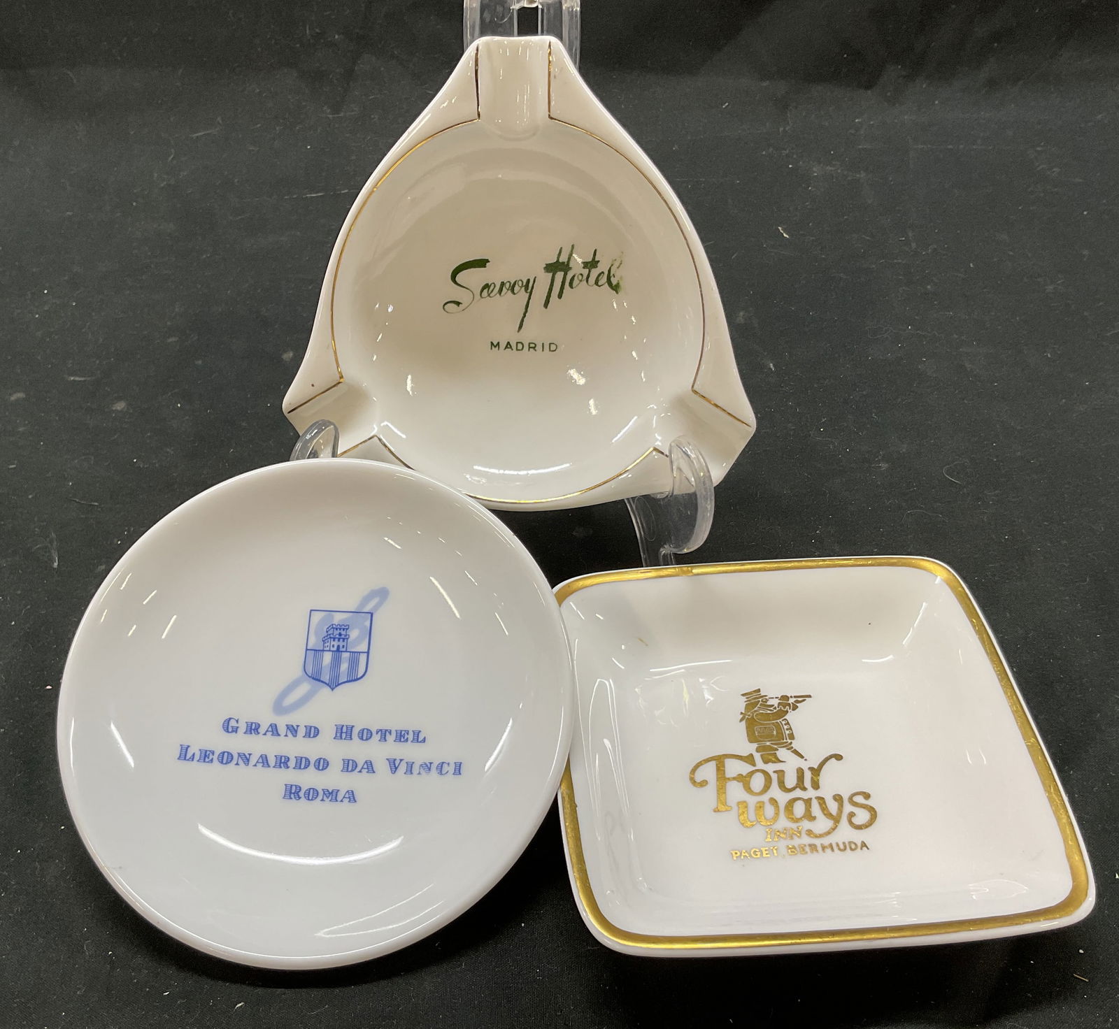 Lot 3 Hotel Souvenir Porcelain Ashtrays England+: Lot of 3 hotel souvenir porcelain ashtrays. Square ashtray that reads Four ways Inn Paget, Bermuda on the front and Wedgwood Bone China Hotelware Made In England on the back. Gilt accents and letterin