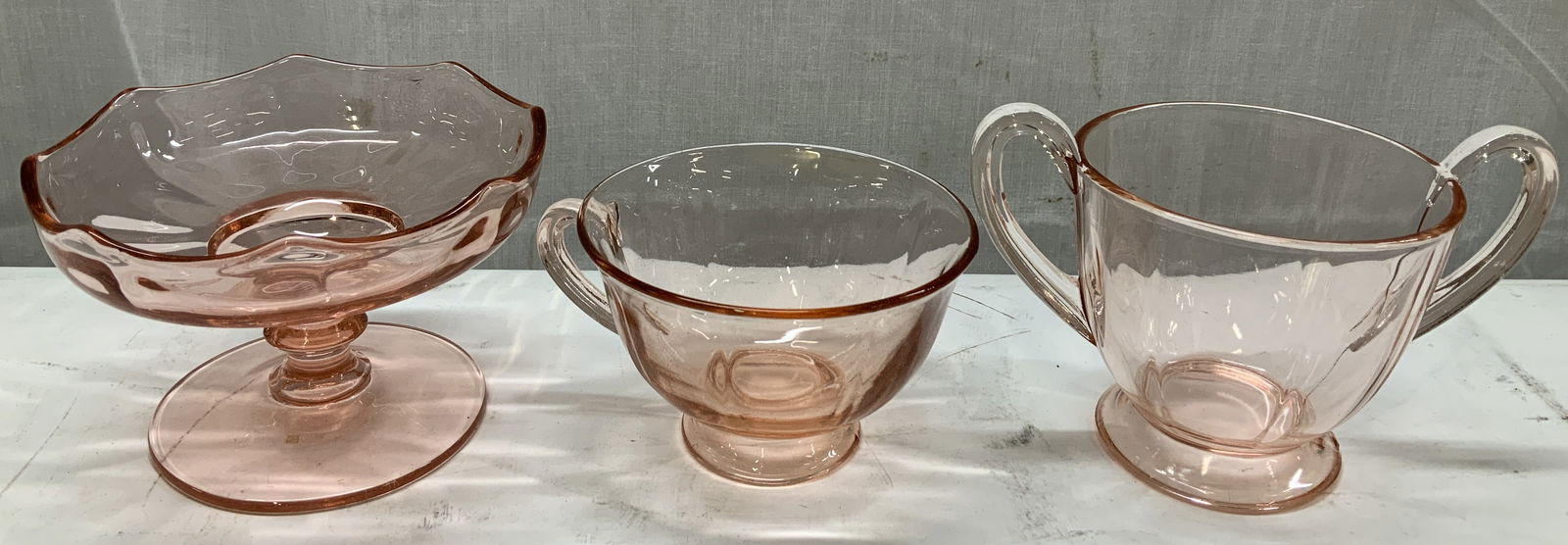Lot 3 Vtg Pink Depression Glass Tableware: Lot includes, 1 teacup, 1 open footed sugar bowl & 1 pedestal dish. Pieces are pink depression glass. No visible signature or markings. Surface wear consistent to age, use & exposure. Measurements: le
