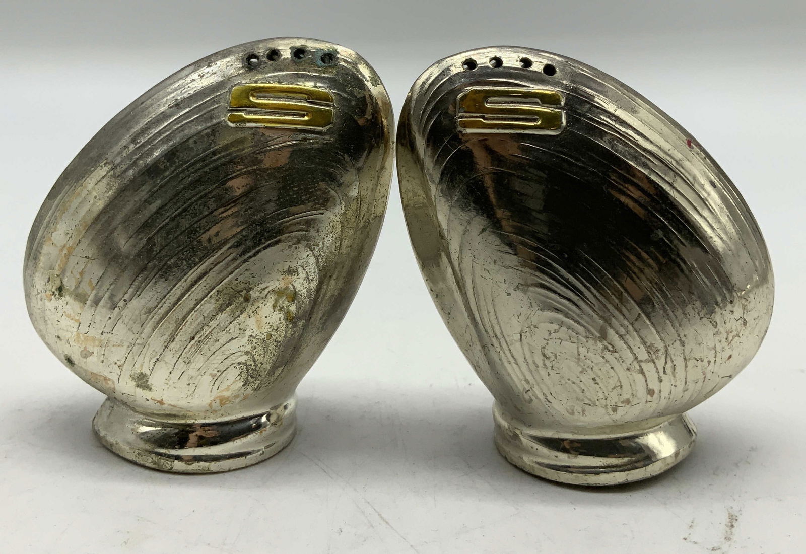 Pair Vtg Clam Silver Plated Salt Shakers: Lot includes, a pair of vintage clam silver-plated shakers. Shaped like clams & is marked S in gold toned. Property of opera singers estate from the renowned & opulent Manhattan landmark. The Ansonia.