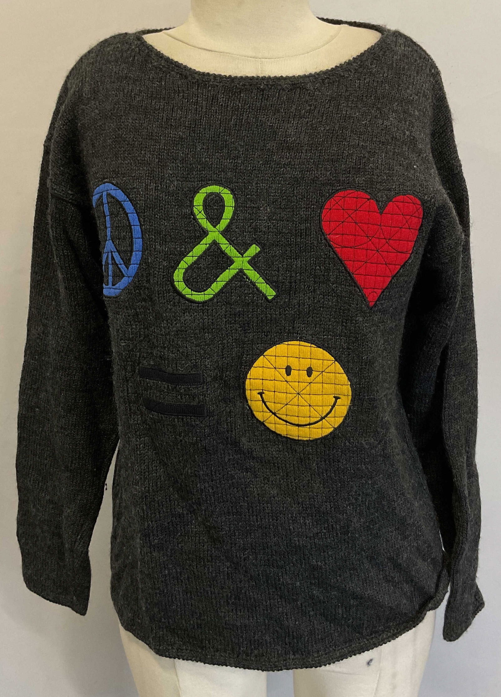 Cheap And Chic Moschino Patched Sweater Italy: Cheap and Chic by Moschino black symbol patch design sweater. Measures approx 19 inches across chest. Made in Italy. Wool material. Features symbol patches on the front including blue peace sign, gree