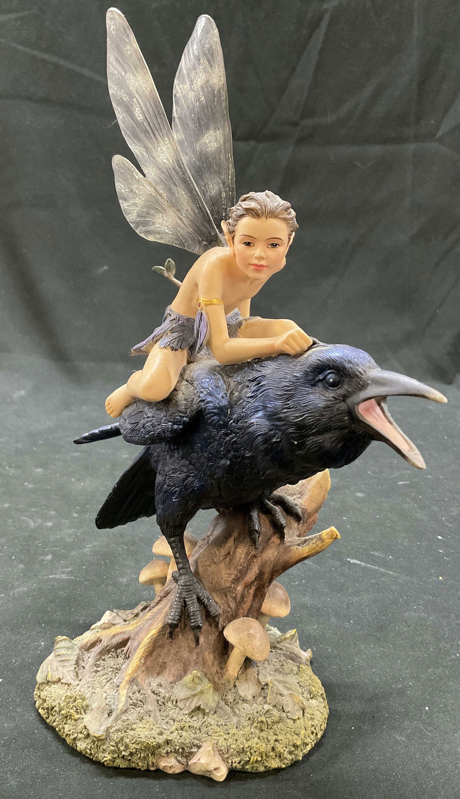 Dragonsite Sheila Wolk Dusk Fairy Figurine: Dragonsite Sheila Wolk Dusk SW 41050 fairy on black raven figurine. Underside reads SW41050. Figure is hand painted and made of resin. Features of fairy include brown hair, black and blue leafy outfit