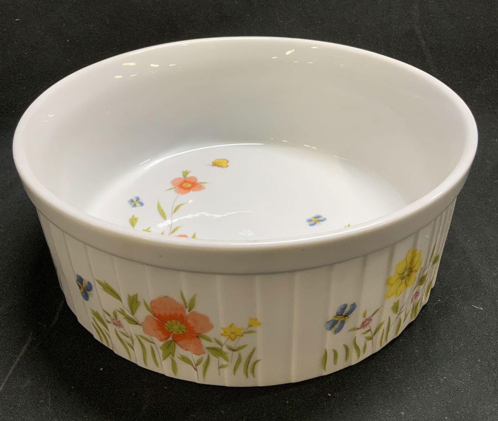 Andrea By Sadek Country Flowers Souffle Dish JAPAN: Andrea By Sadek Country Flowers souffle dish features a floral pattern of orange & yellow with green leaves. Butterfly motifs & ribbed exterior. Porcelain material. Signed & marked on underside. Reads