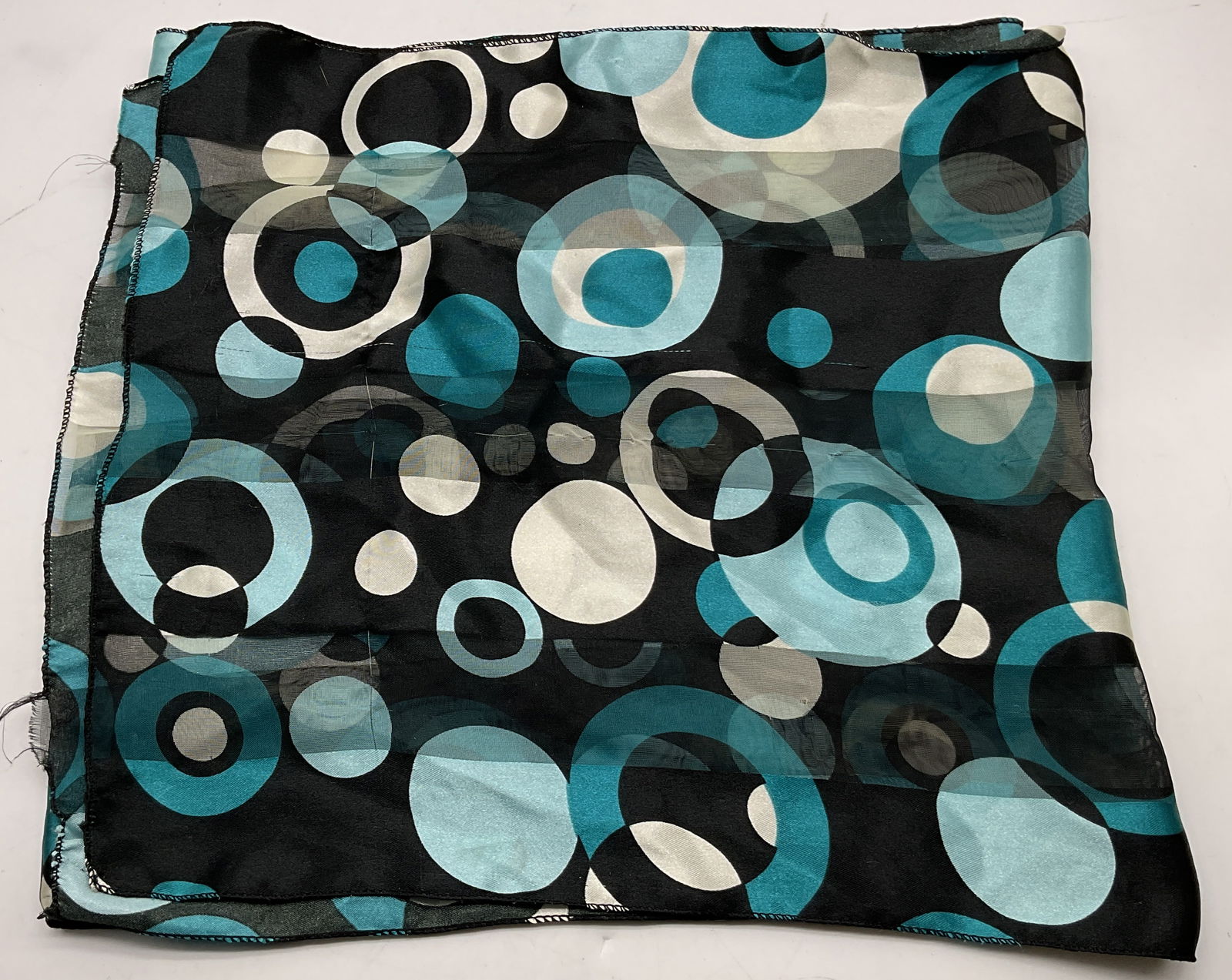 Vintage Black & Blue Sheer Silk Scarf: Vintage black and blue sheer silk scarf. Silk material. Striped black pattern with sheer accents. Circular bubble pattern in blue, white, and black. Measures approx 13 1/2 x 53 inches. Pull to stitchi