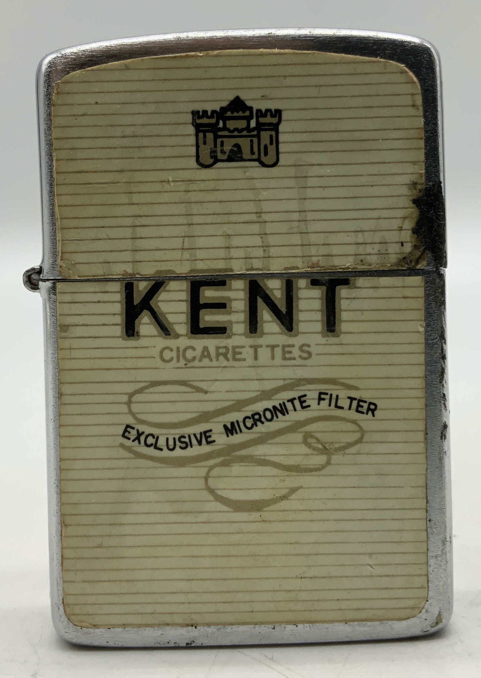 C.1960s Hadson Kent Cigarettes Advertising Lighter: Vintage 1960s Hadson Kent Cigarettes advertising lighter. It features the Kent logo and the text EXCLUSIVE MICRONITE FILTER. Silver toned. Surface wear consistent to age, use & exposure. Signed & mark