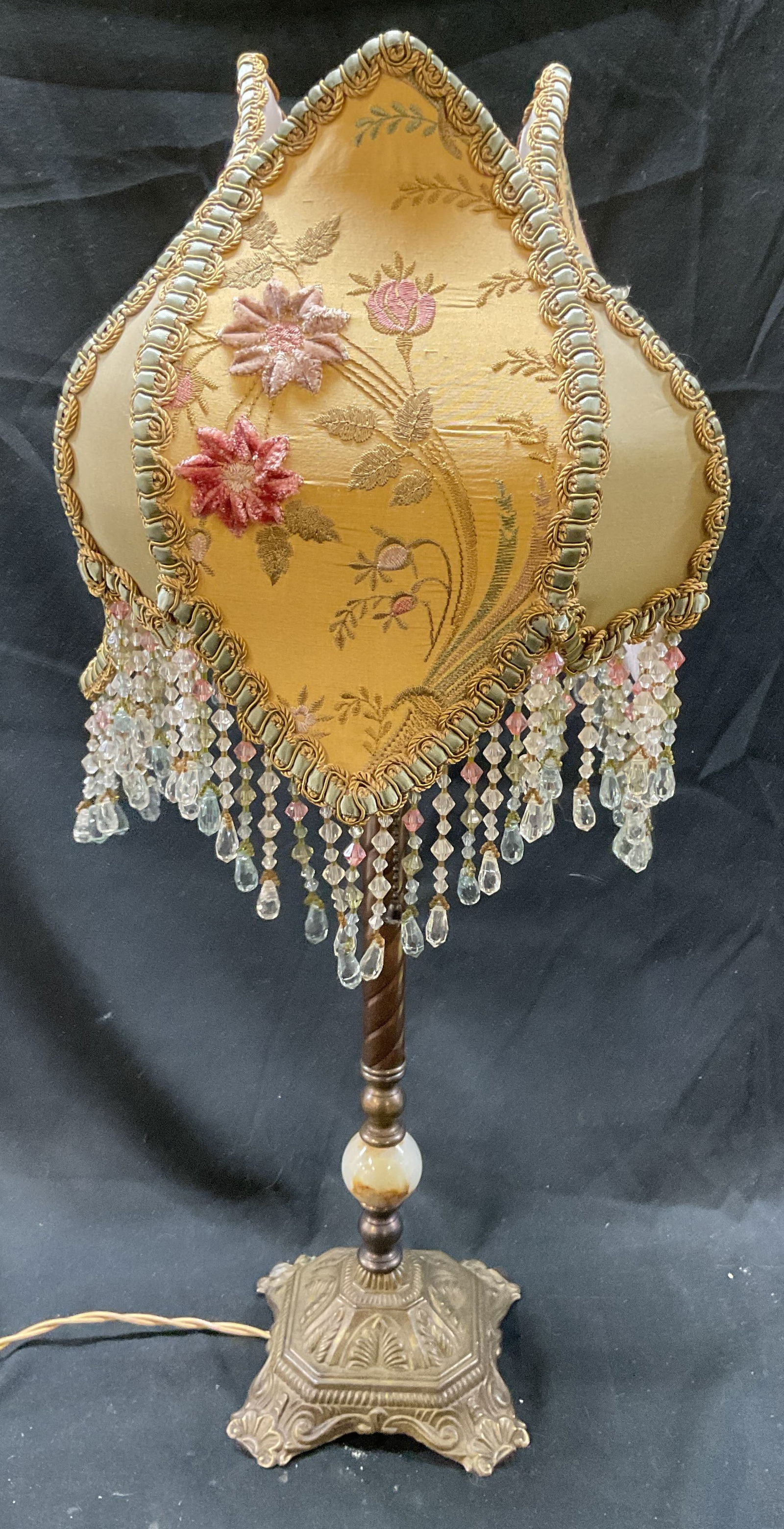 Victorian Style Brass Stone Beaded Shade Lamp: Vintage, possibly antique, Victorian style table lamp. Brass base with polished stone orb. Ornate scroll pattern on base. Decorative fabric shade with embroidered floral detail and beaded fringe. Meas