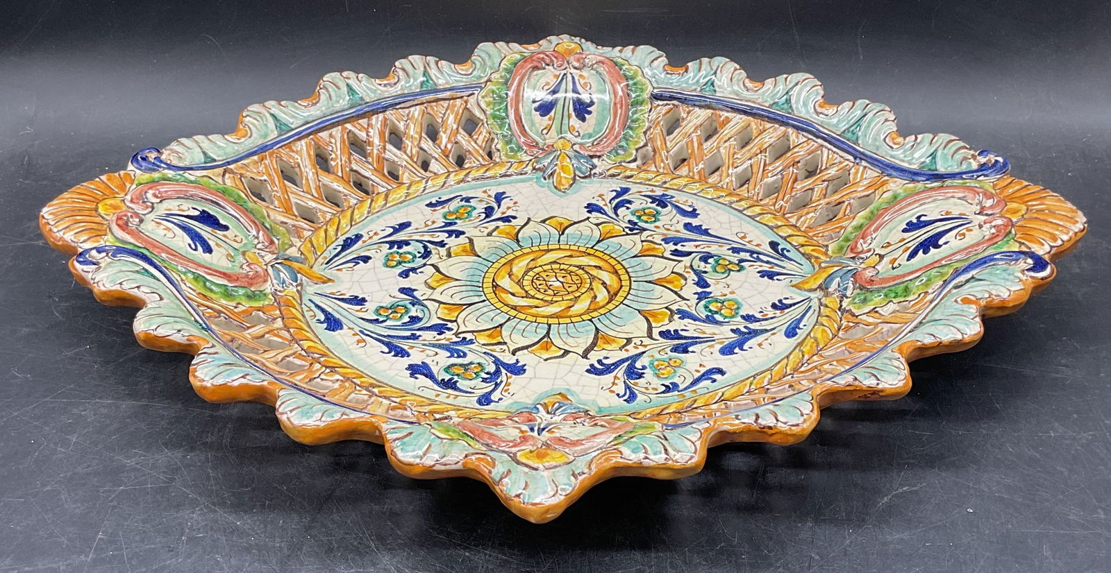 Signed Sciacca Ceramic Floral Bowl, Sicily: Signed Sciacca artisan ceramic bowl. Handmade and hand painted with ornate floral design. Reticulated border and scalloped rim. Measures approx 16 x 13.5 x 2 inches. Signed. Made in Sicily. Wear