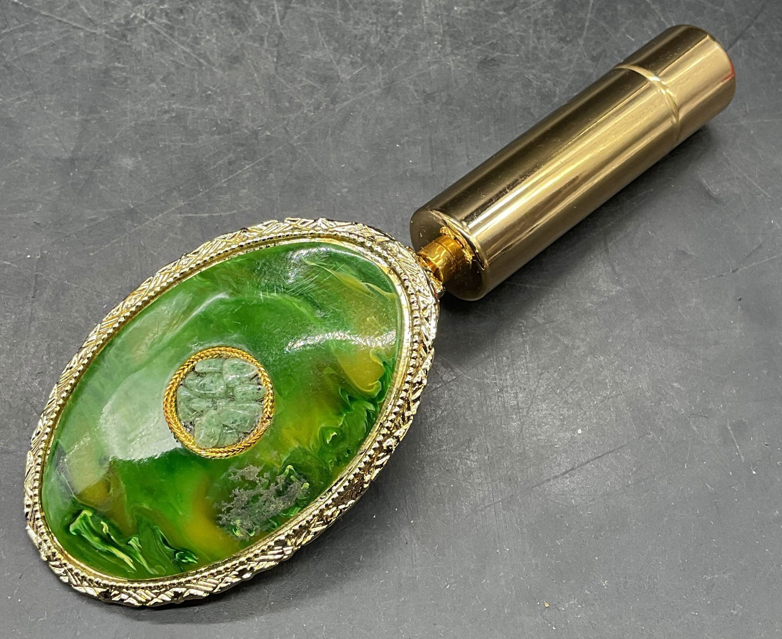 Vintage Gold Tn Green Lipstick Holder Mirror: Vintage lipstick holder and hand mirror. Hinged. Gold tone with marbled green lucite and stone cover. Measures approx 5.5 x 1.75 inches. Some scratching and residue. Property of opera singers estate f