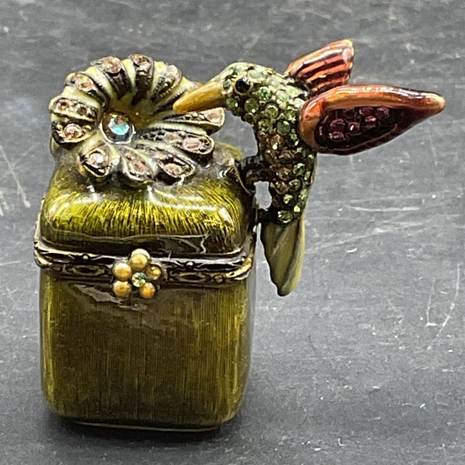 Jay Strongwater Enamel Hummingbird Pill Box: Signed Jay Strongwater pill box. Hummingbird motif. Green enamel with crystal decoration. Measures approx 1.5 x .75 x 1.5 inches. Some wear consistent with exposure. Jay STRONGWATER pill bow, enamel p