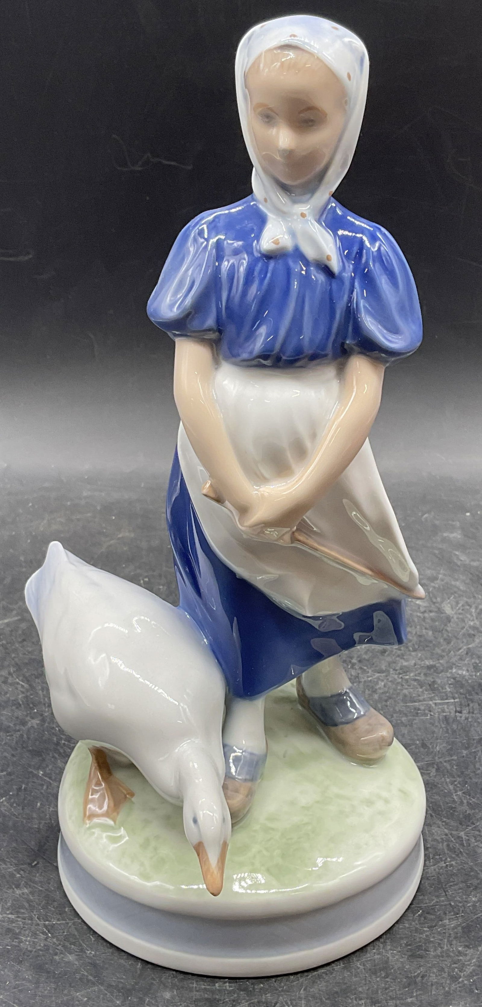 Royal Copenhagen Girl w Goose Porcelain Figurine: Royal Copenhagen Girl With Goose porcelain figurine. Hand painted. Signed. Made in Denmark. Measures approx 5 x 5 x 9 inches. Some wear consistent with exposure. Royal Copenhagen figurine, porcelain f