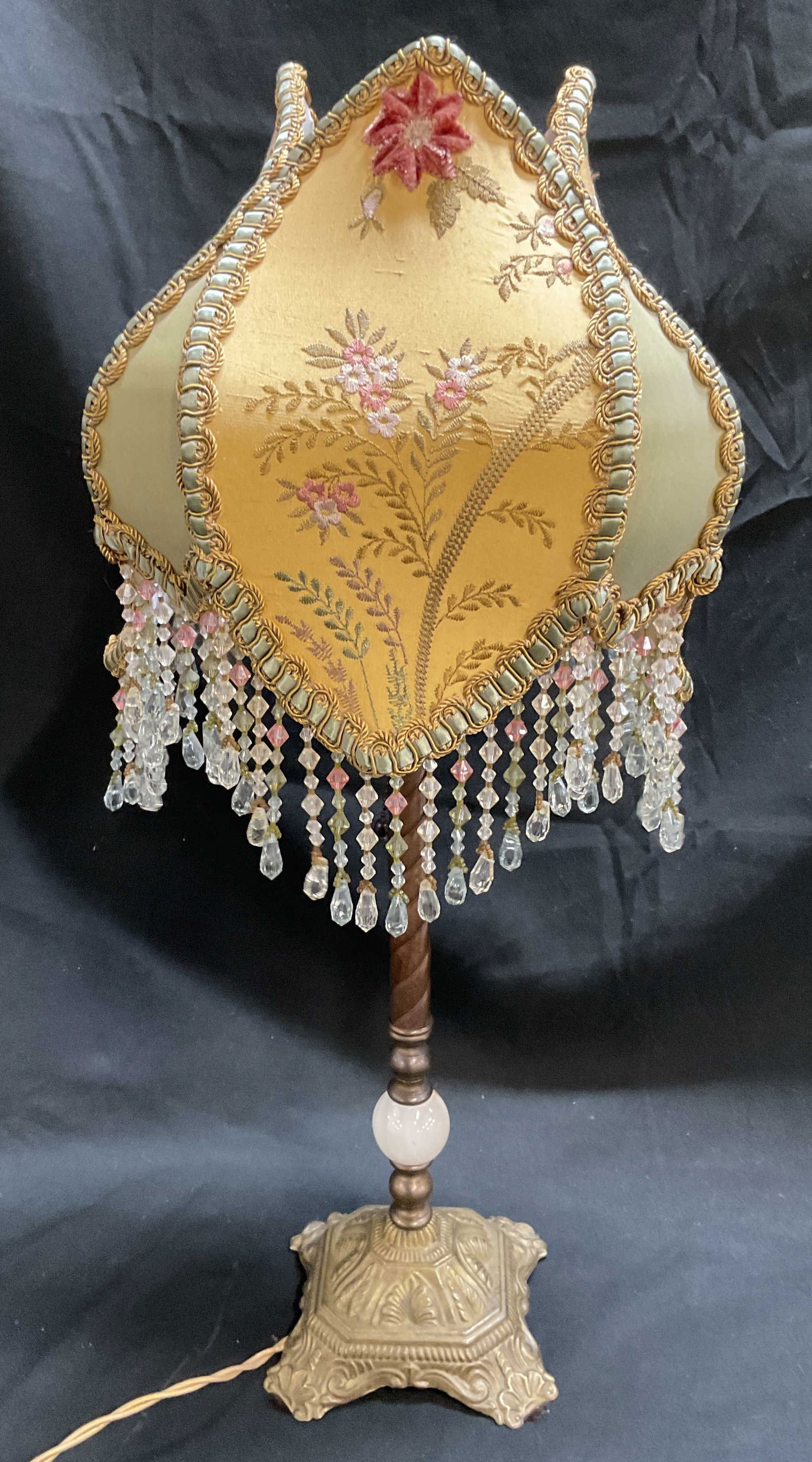 Victorian Style Brass Stone Beaded Shade Lamp: Vintage, possibly antique, Victorian style table lamp. Brass base with polished stone orb. Ornate scroll pattern on base. Decorative fabric shade with embroidered floral detail and beaded fringe. Meas