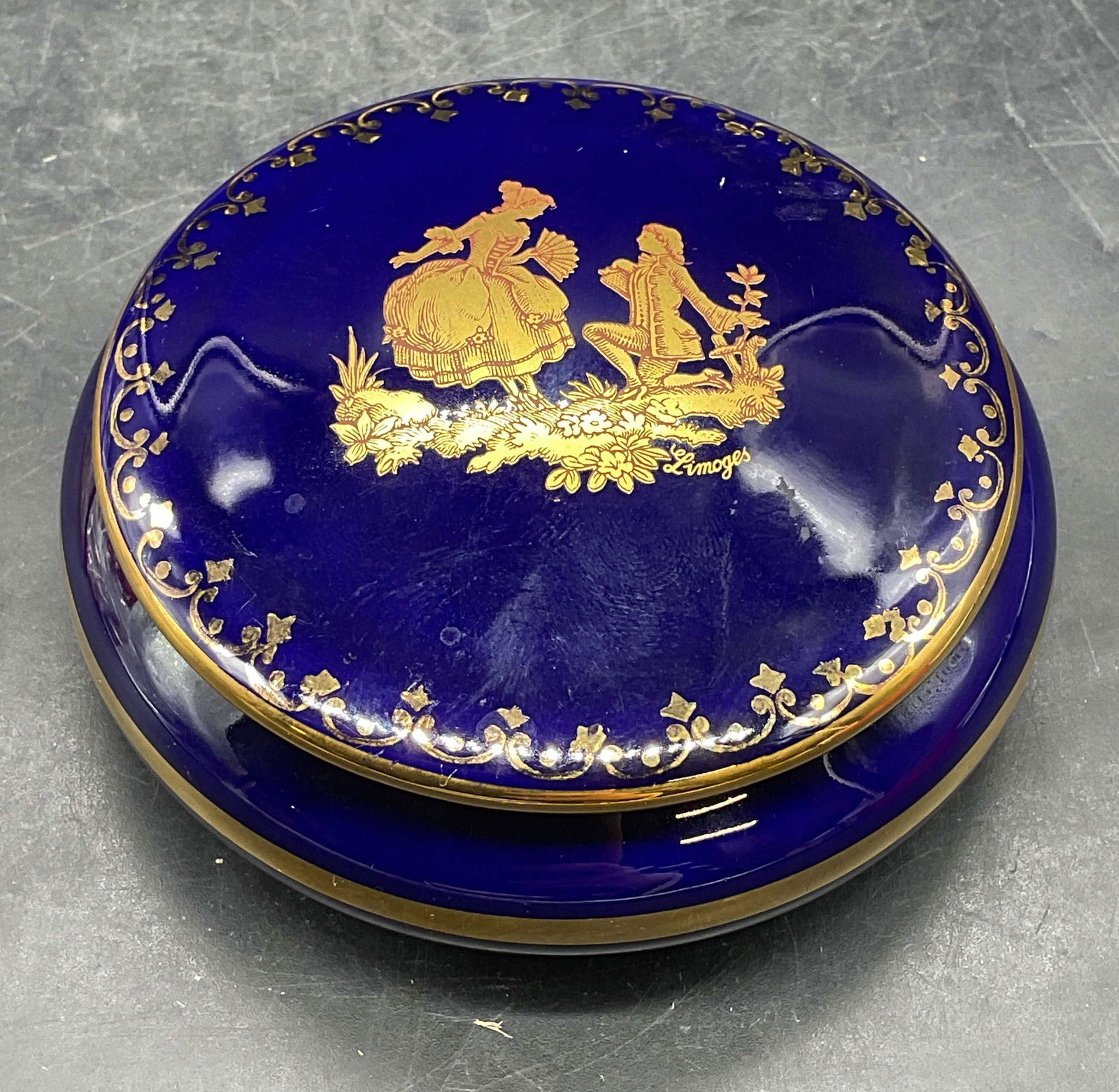 Legrand Lebouc Limoges Cobalt Porc Trinket Box: Signed Legrand Lebouc Limoges porcelain trinket box. Cobalt blue with gilt decoration. Couple motif. Measures approx 3.25 x 1 inches. Made in France. Some scratching. Legrand Lebouc trinket box, Limog