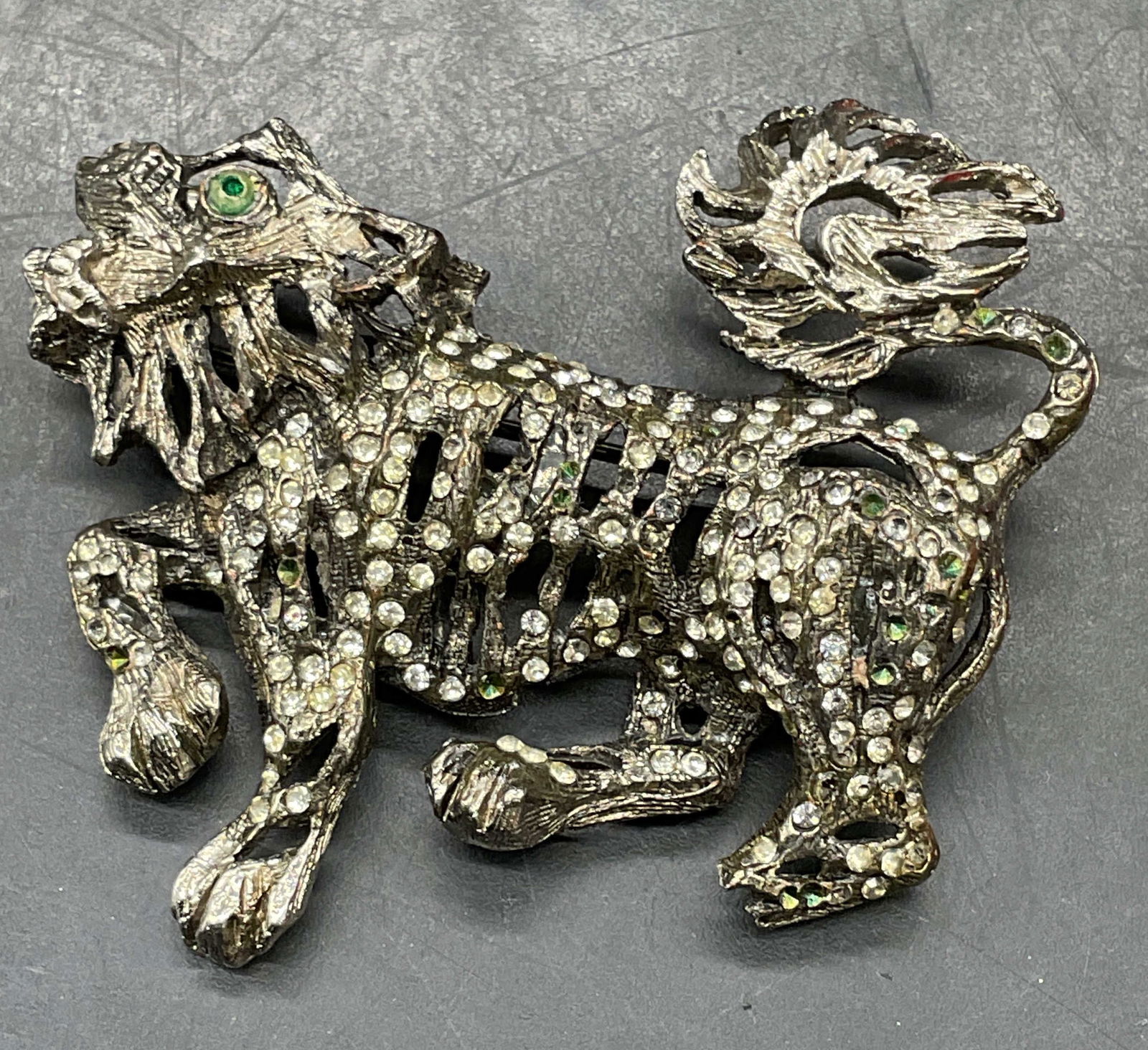 Vintage Silver Tone Crystal Food Dog Brooch: Vintage silver tone foo dog brooch with colorless and green crystals. Measures approx. 1.5 x 2 inches. Some scratching. Some crystals need replacement. Jewelry, estate jewelry, costume jewelry,