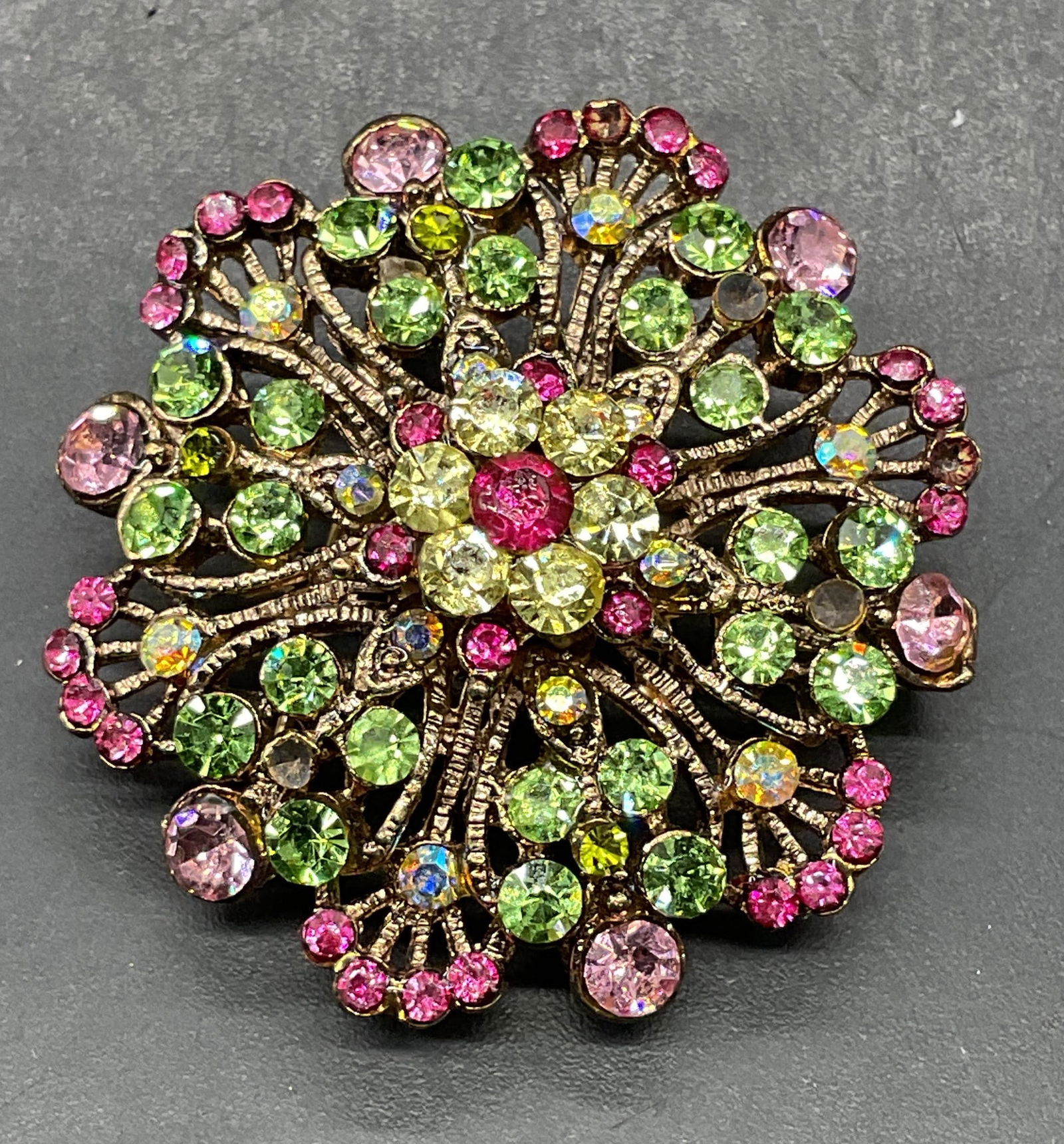 Gold Tone Pink Green Crystal Flower Brooch: Vintage gold tone flower brooch/pendant with pink and green crystals. Measures approx. 1.25 inches wide. Some scratching. Some crystals need replacement. Jewelry, estate jewelry, costume jewelry,