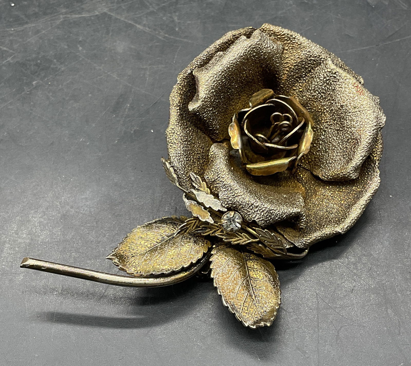 Vintage Sandor Gold Tn Crystal Flower Brooch: Vintage signed Sandor gold tone crystal decorated flower brooch. Measures approx. 3.75 x 2.5 inches. Some scratching and loss to finish. Jewelry, estate jewelry, costume jewelry, cocktail jewelry,