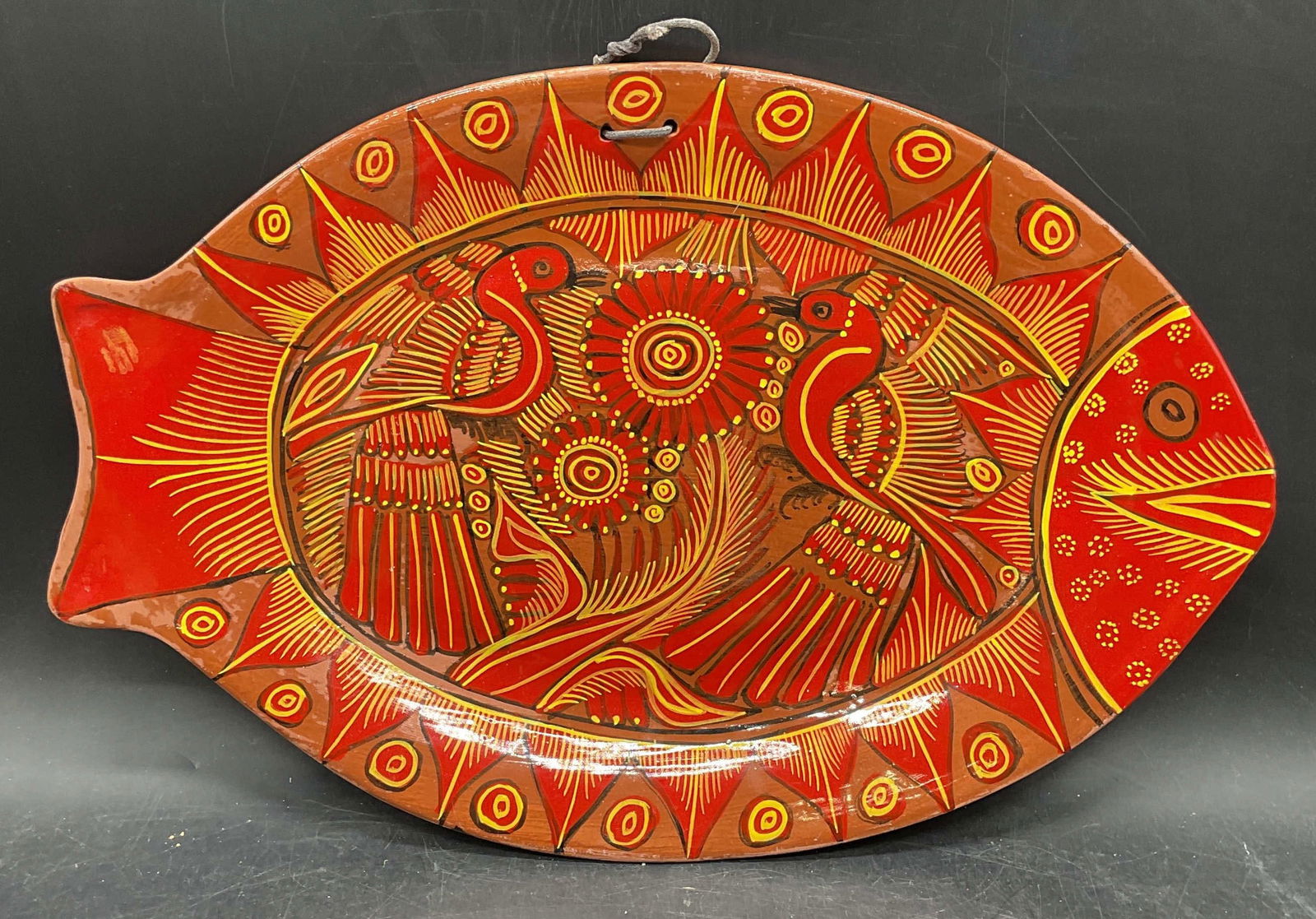 Hand Painted Red Fish Terracotta Plate: Handmade and hand painted terracotta fish motif plate. Red and yellow with bird design. Measures approx. 14 x 9.25 inches. Wear including loss to pigments and scratching. Fish plate, wall plate, decor