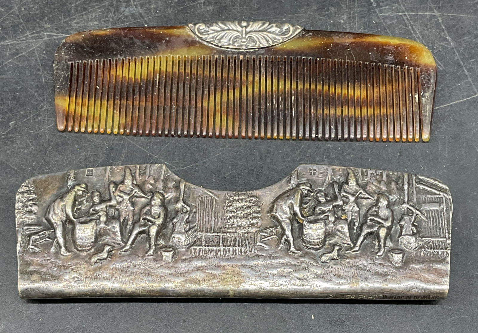 Vintage Silver Plated Figural Comb, Denmark: Vintage silver plated comb case and comb. Made in Denmark. Repousse village life figural scene. Measures approx. 4 x 1.25 inches. Some patina and scratching. Silver plated comb, vintage comb, figural