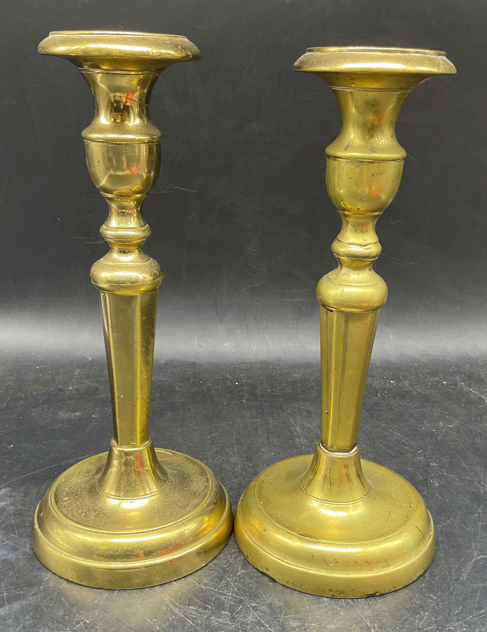 Pair Vintage Heavy Brass Candlesticks: Pair of vintage heavy cast brass candlesticks with round bases and fluted sconces. Measures approx. 4.5 x 10.5 inches, wear including patina and scratching. Brass candlesticks, vintage candlesticks, h
