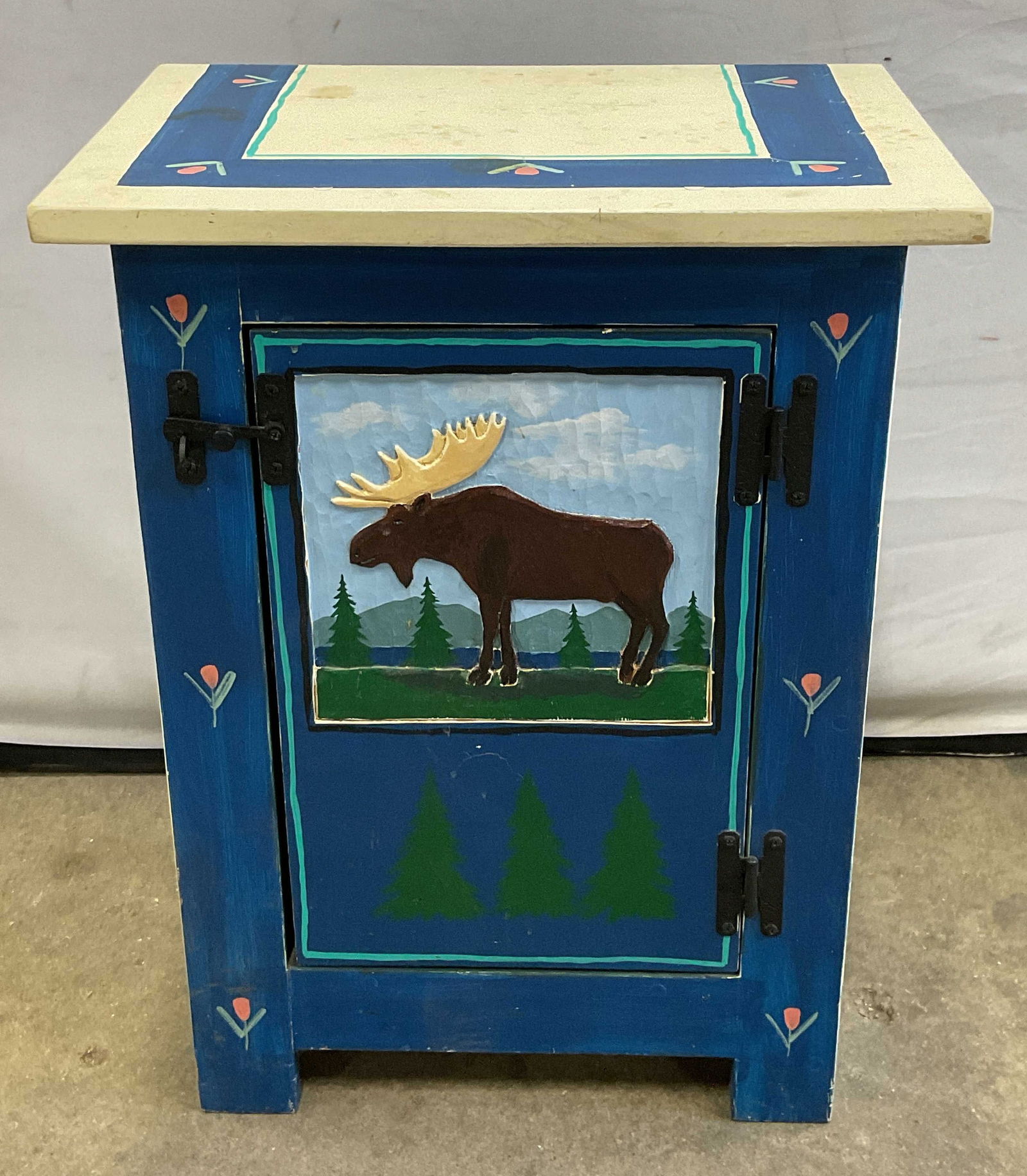 Pedro Chavez Taos NM Moose End Table 1997: Vintage handcrafted end table. Signed Pedro Chavez, Taos, New Mexico and dated 1997. Hand painted floral and tree pattern with carved moose motif on lower cabinet door. Measures approx. 18.5 x 13.25 x