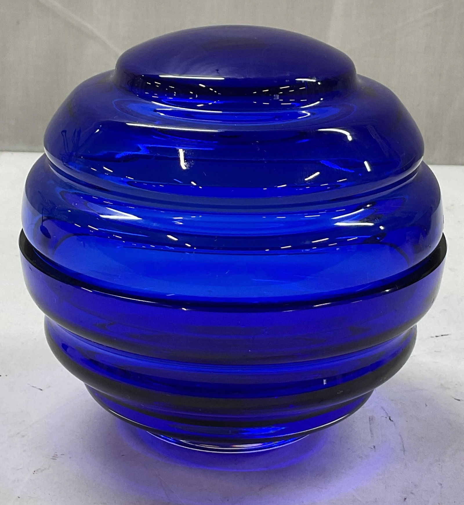 Nude Nest Cobalt Blue Lidded Art Glass Candy Dish: Nude Nest cobalt blue lidded art glass candy dish. Marked Nude on underside. Round orb ribbed shape with removable lid. Bright cobalt blue. Measures ht approx 6 inches diam approx 6 inches.