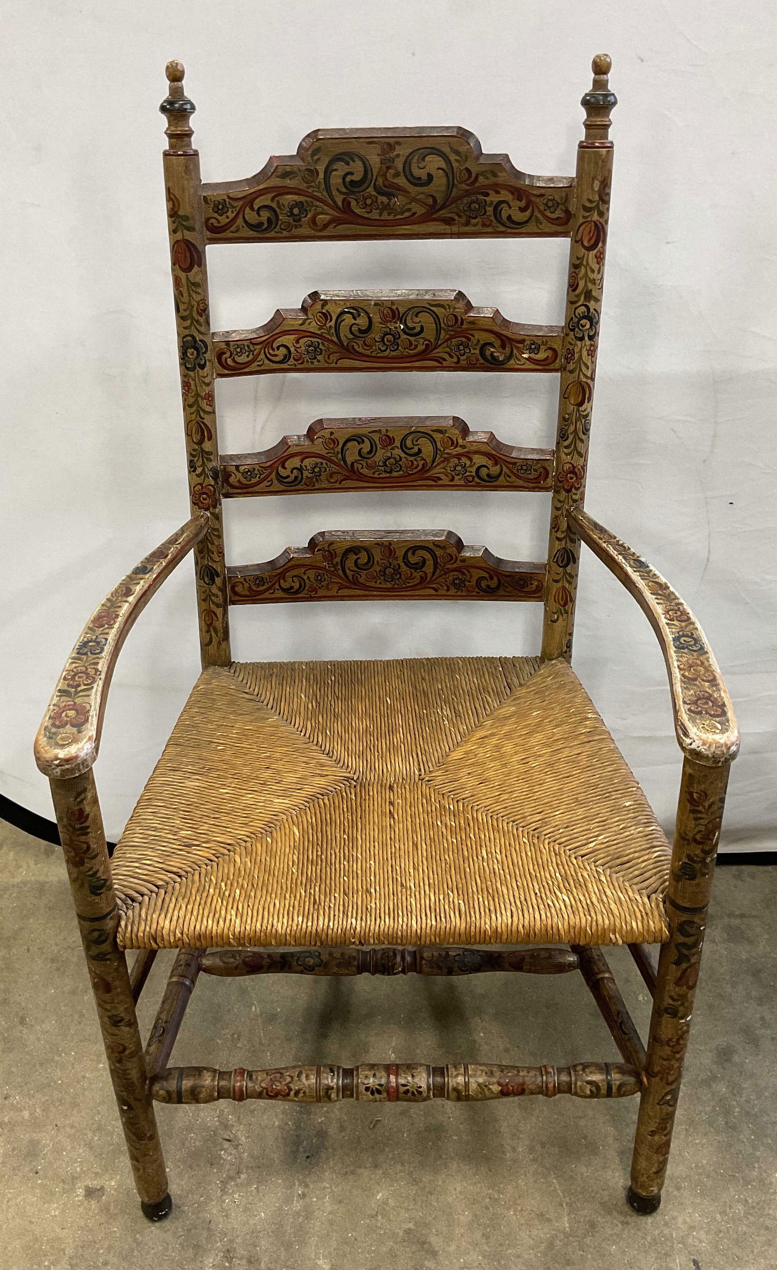 Signed Antique Ladder Back Rush Seat Chair: Signed Antique wood ladder back armchair with rush seat. Hand painted floral design. Signed illegibly with stamp. Measures approx. 22.75 x 17 x 43.5 inches. wear including scratching and loss to