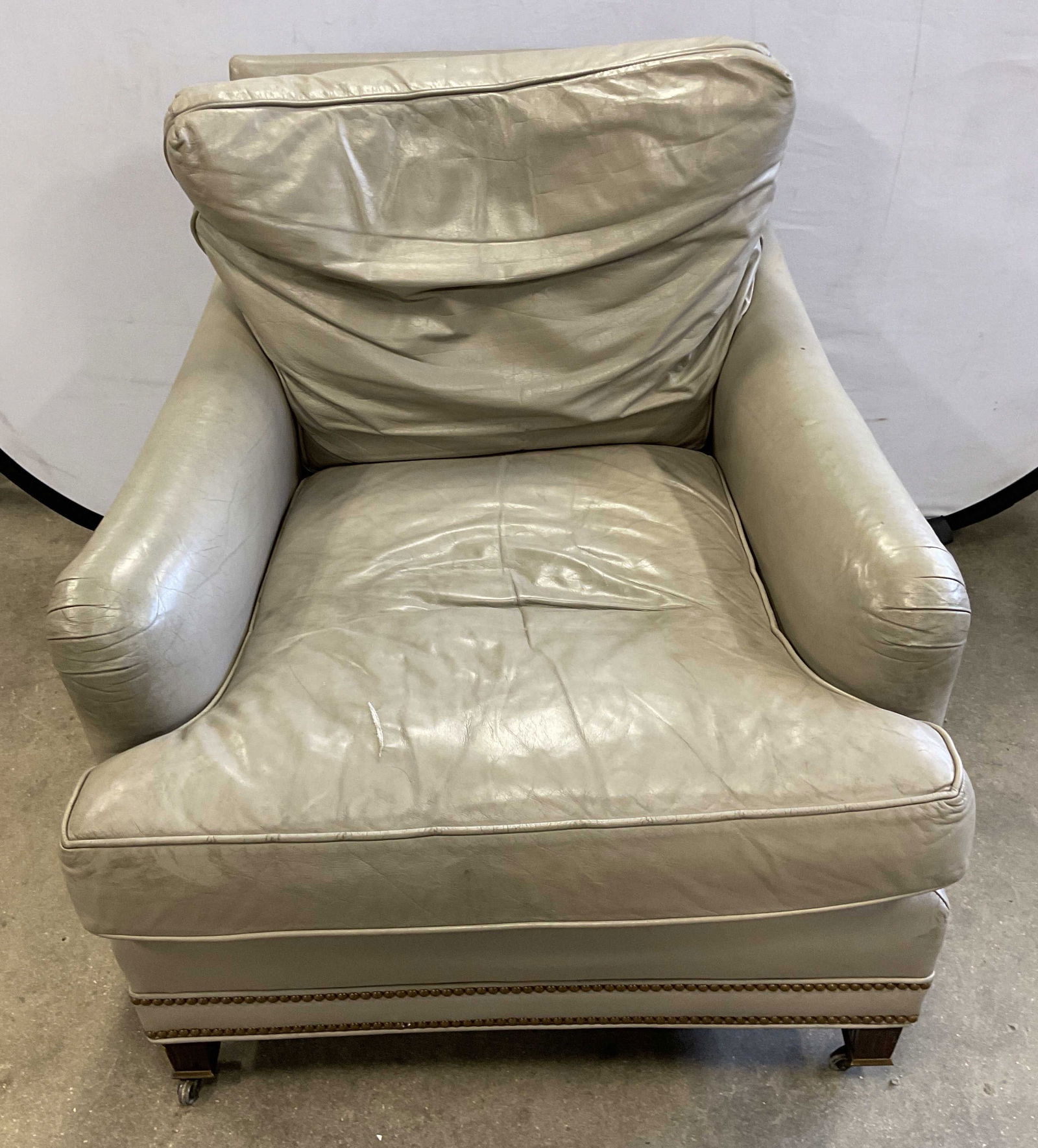 Hancock & Moor Gray Leather Nailhead Armchair: Hancock & Moore gray leather upholstered armchair with nailhead trim. Casters on front legs. Signed. Measures approx. 31 x 36 x 32 inches. Wear including scratching, discoloration and some tearing
