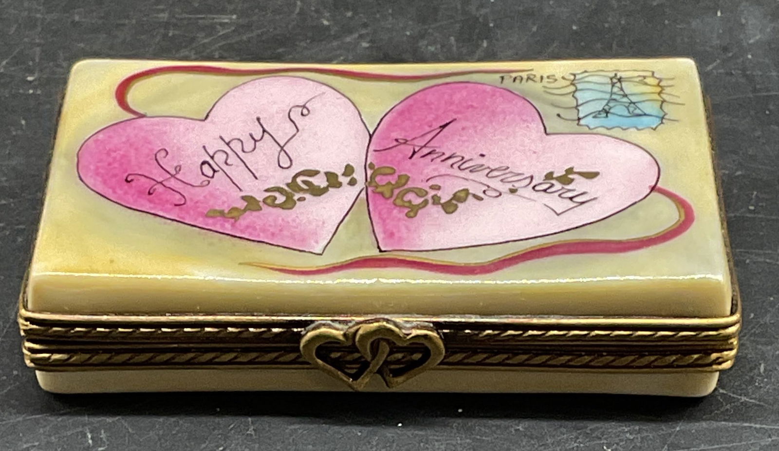 ROCHARD Limoges Porcelain Anniversary Trinket Box: Signed Rochard Limoges porcelain trinket box. Anniversary letter, Eiffel Tower and heart motif. Hand painted made in France. Measures approx. 2.25 x 1.5 x .5 inches. Some scratching. Limoges trinket b