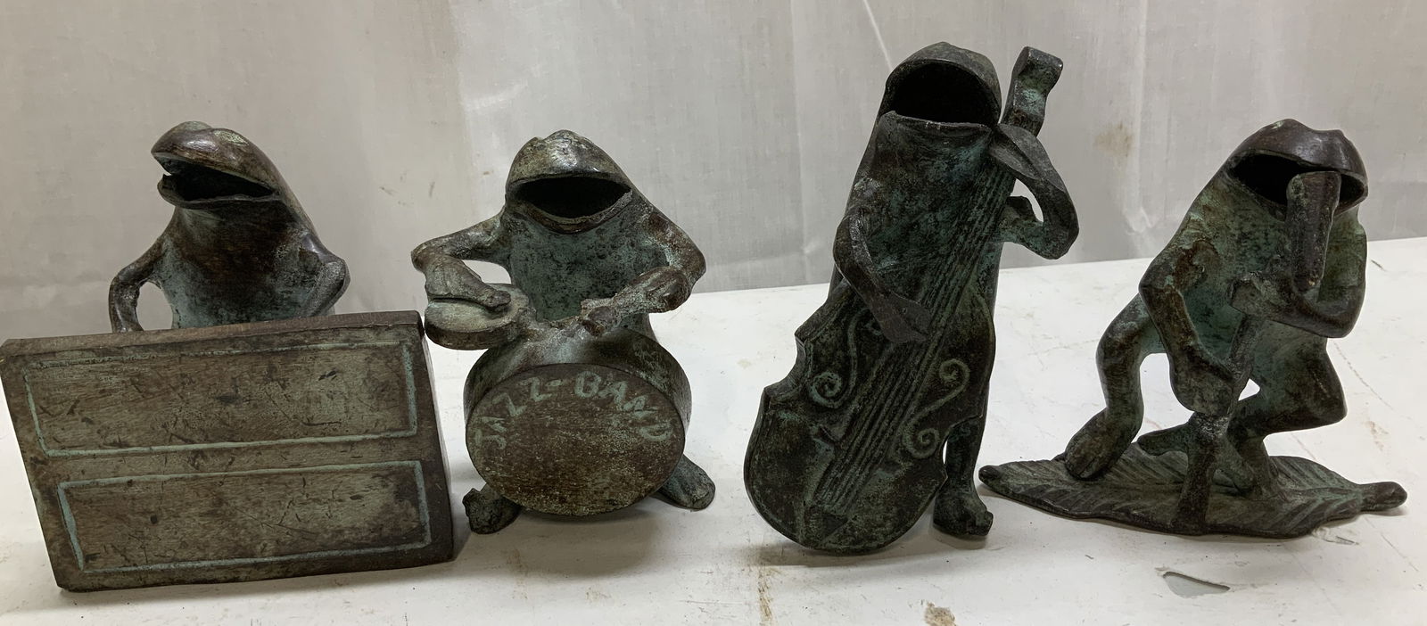 Set 4 Jazz Band Bronze Frog Figurines: Lot includes, set 4 of jazz band frog figurines. Individual frogs playing different instruments. Bronze material. Surface wear consistent to age, use & exposure. Measurements: length 3.7in x width 2.5