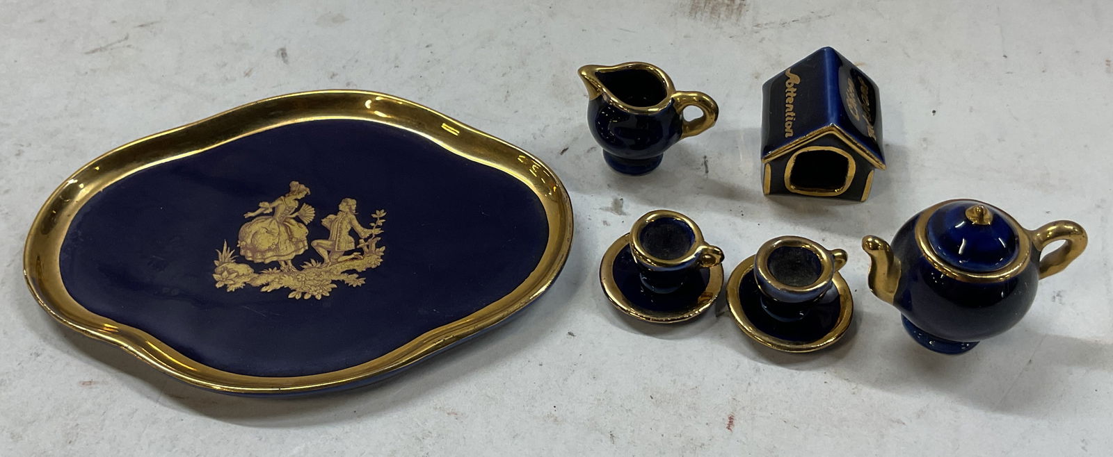 Lot 9 Limoges Cobalt Blue Porc Mini Tea Set France: 9 piece Limoges cobalt blue porcelain miniature tea set. Marked Limoges France. Includes 1 tray, 1 teapot with lid, 1 creamer, 2 teacups, 2 saucers, and 1 miscellaneous house figure. Cobalt blue with