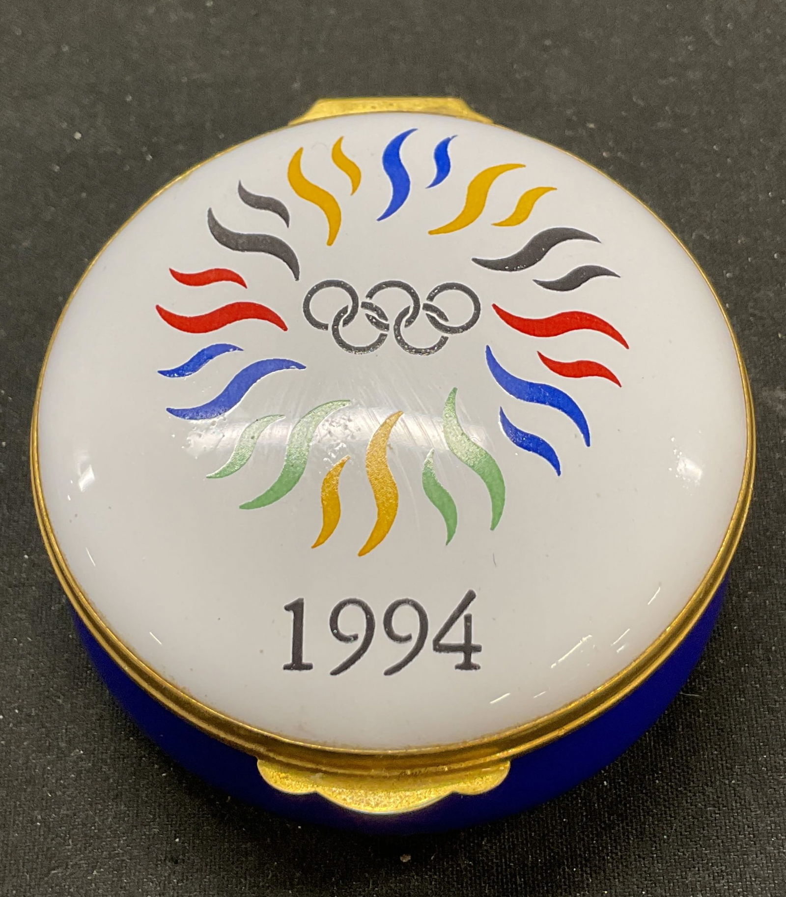 1994 Crummles & Co Olympic Trinket Box England: Crummles & Co porcelain hinged trinket box. Marked on underside, reads Made In England By Crummles & Co. Features the 1994 Lillehammer Olympic logo. From the Winter Olympics in Norway in 1994.