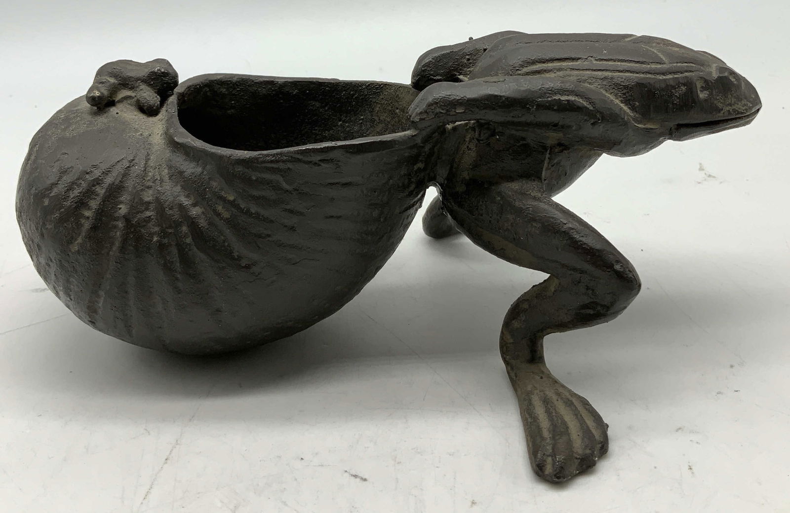 Vtg Cast Iron Frog Pulling Snail Shell Fig JAPAN: Vintage cast iron figurine depicting a frog pulling a snail shell. Shell has an opening at top. Black toned. Signed & marked on underside. Reads, MADE IN JAPAN. Surface wear consistent to age,