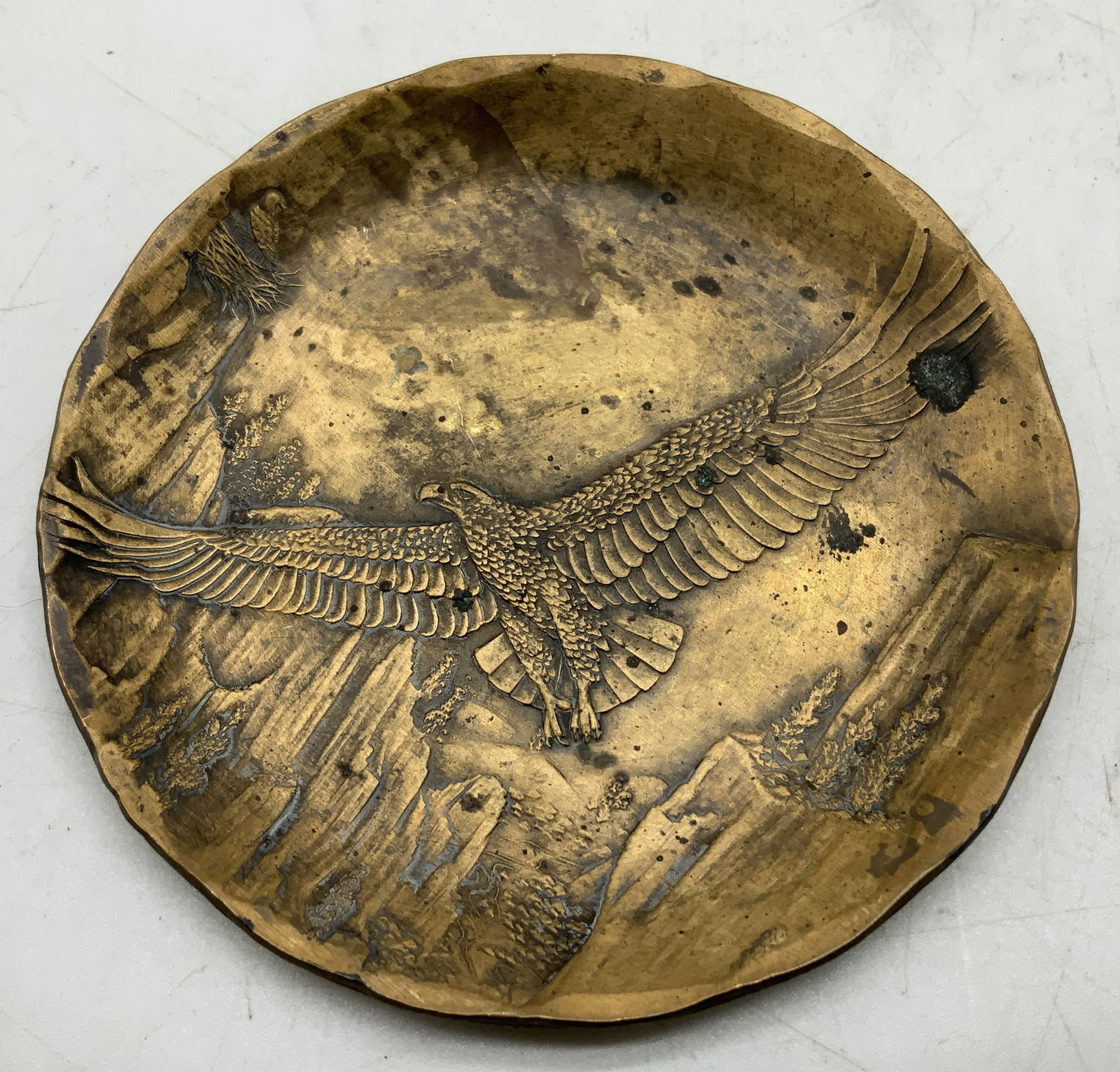 Wendell August Forge Solid Bronze Dish PA: Wendell August Forge solid bronze dish features a central design of a bald eagle & mountains in the back. Round shape. Signed & marked on underside. Reads, HAND MADE. WENDELL AUGUST FORGE. GROVE CITY,