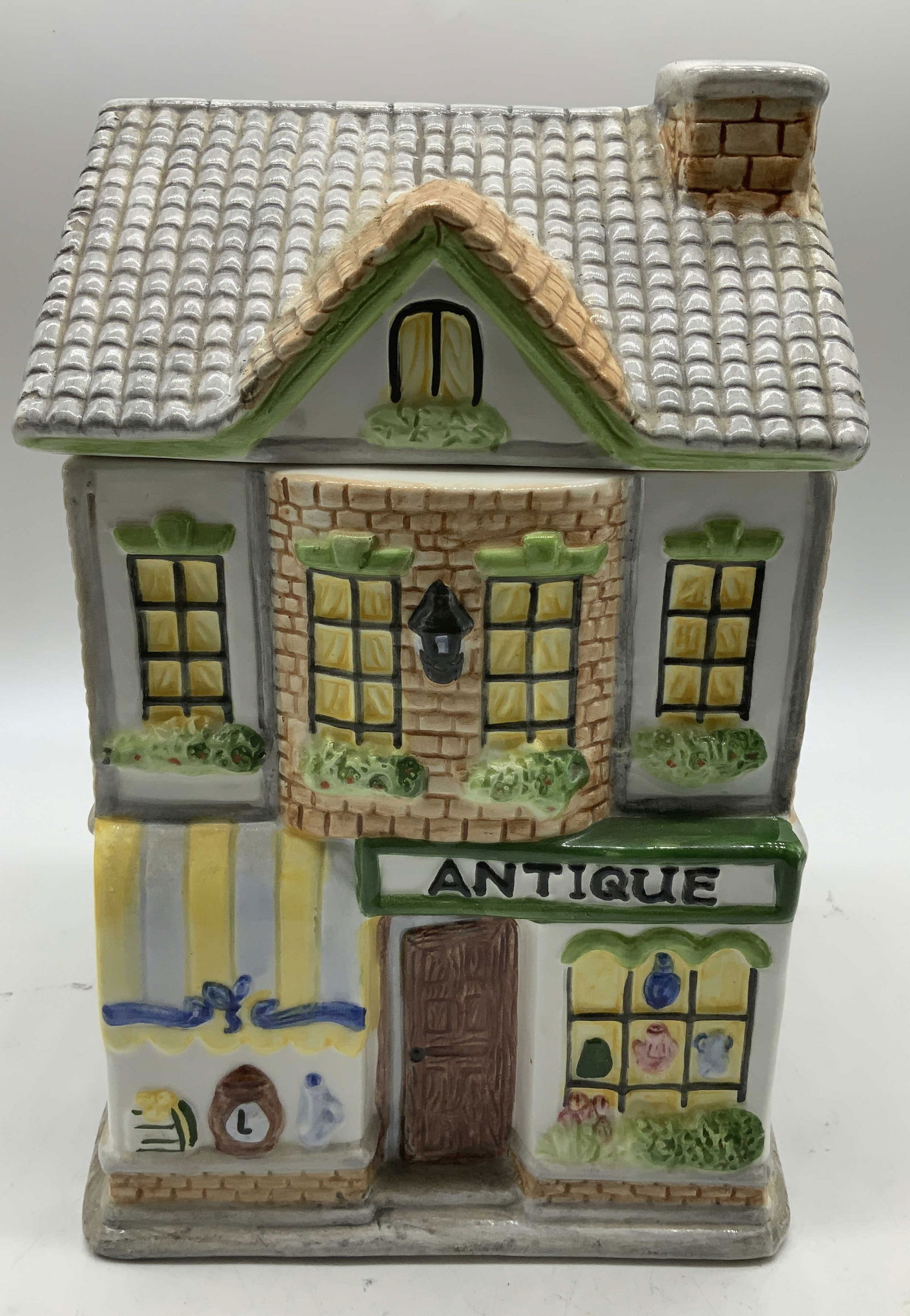 Vtg Starve Industries Antique Store Cookie Jar: Ceramic cookie jar shaped like an antique store building. Hand painted accents. Sign at front reads, ANTIQUE & features collectibles on front. Signed & marked on underside. Reads, STARVE INDUSTRIES IN