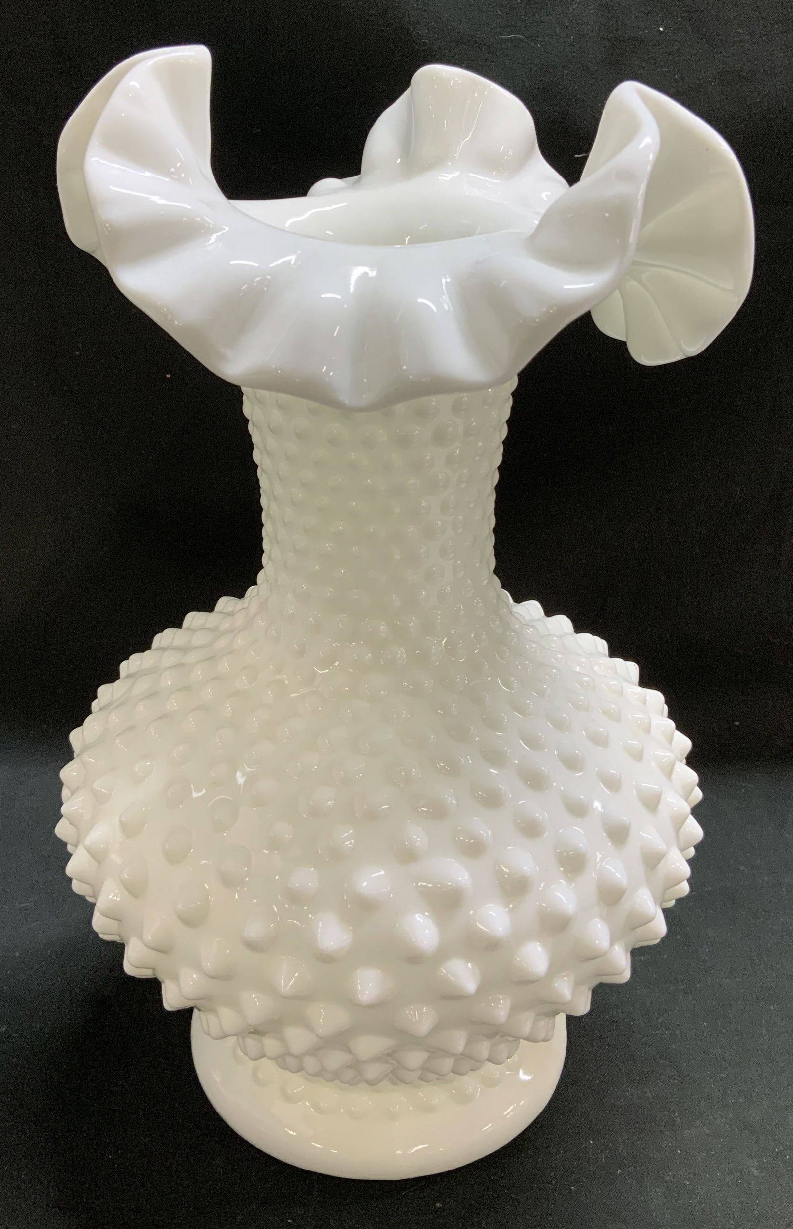 Vtg Fenton Hobnail Milk Glass Vase 10.5in: Vintage Fenton milk glass vase features a ruffled rim & hobnail pattern on body. Raised bumpy dots. Round base. Signed & marked on underside. Reads, FENTON. Surface wear consistent to age, use & expos