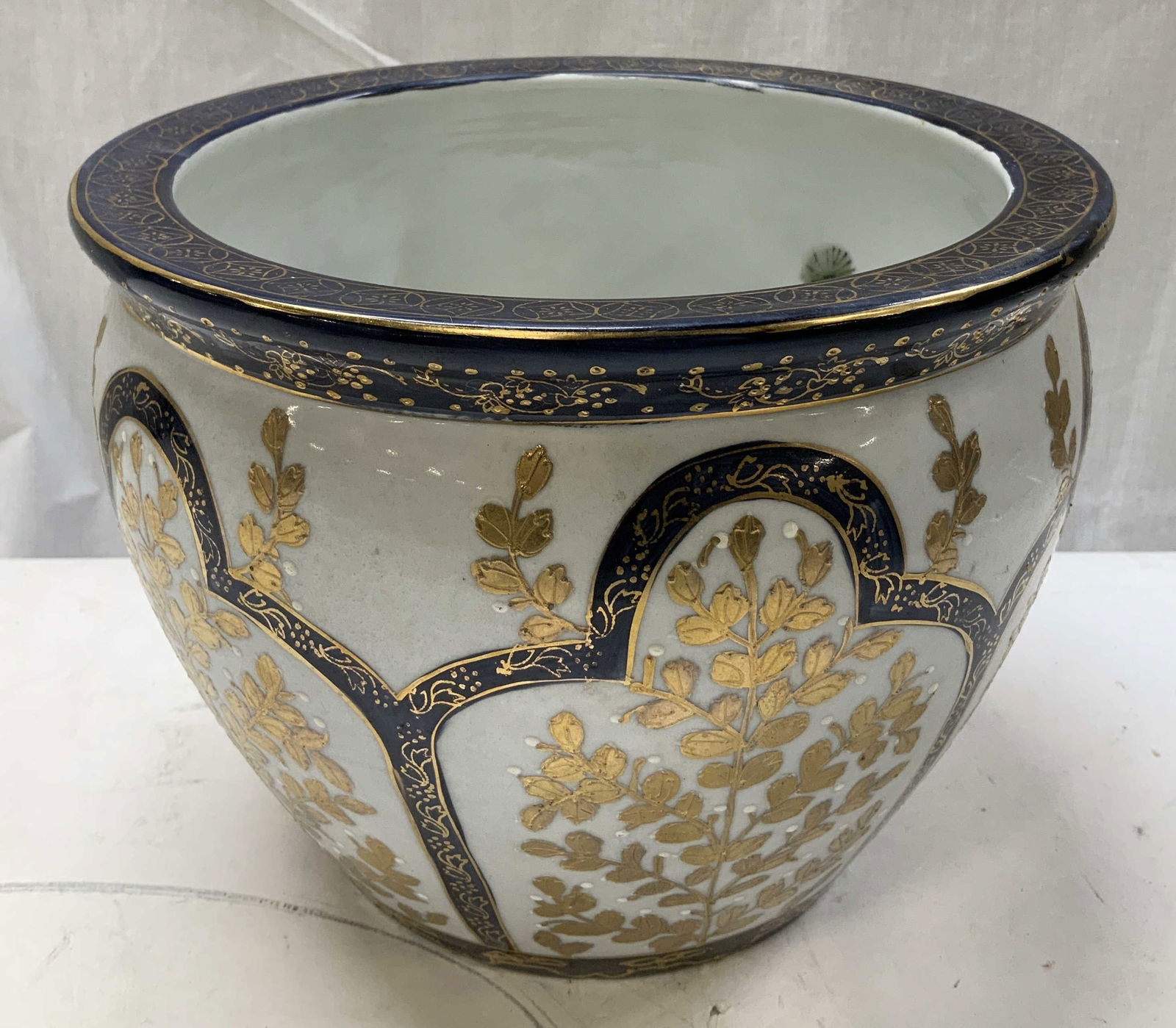 Vtg Hand Painted Gilt Floral Porcelain Vase: Vintage porcelain vase features hand painted gilt floral accents on body. Cobalt toned. Interior of vase features fish motifs. Surface wear consistent to age, use & exposure. Measurements: length 9.8i