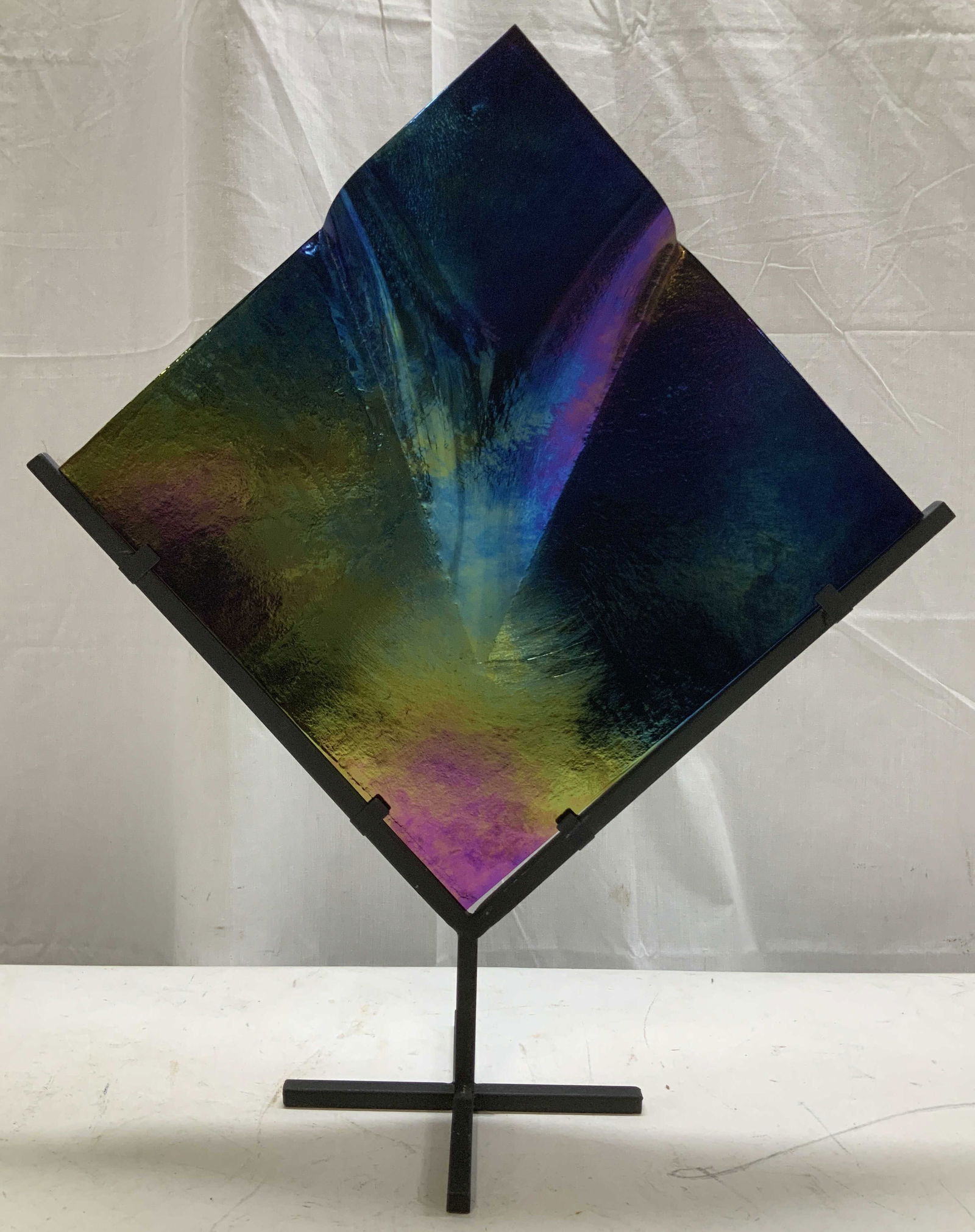 Iridescent Panel Art Sculpture 20in: Art sculpture depicts a diamond shaped panel mounted on a cast iron base. Iridescent surface with shifting colors of blue, purple & green. Opening at top. No visible signature or markings. Sold