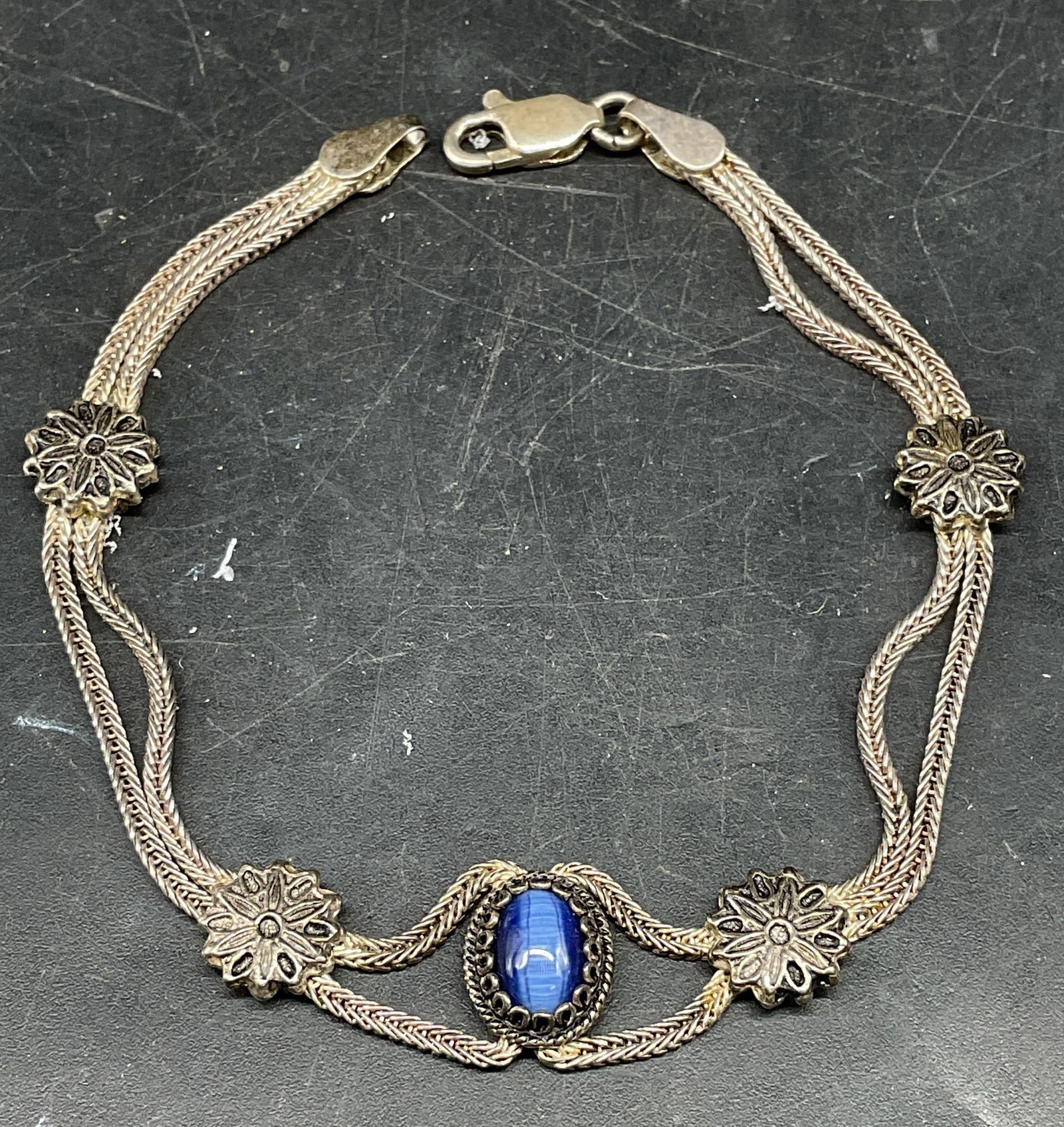 Vintage Sterling Silver Blue Floral Bracelet: Vintage sterling silver bracelet with floral design and blue glass cabochon. Measures approx. 7 inches long. Marked sterling. Total weight 10.6 grams. Some scratching. Jewelry, estate jewelry, fine je