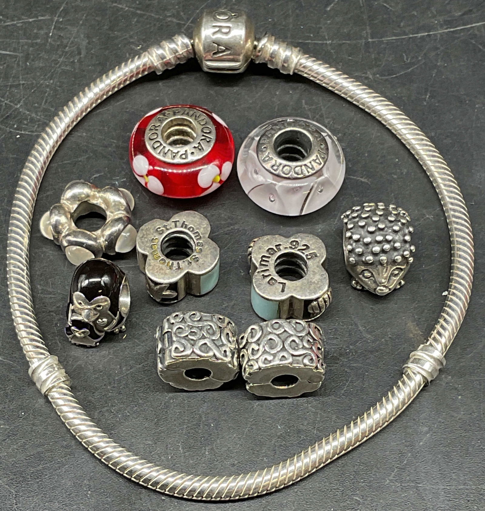 Pandora Sterling Silver Bracelet with Charms: Signed Pandora classic sterling silver bracelet with assorted sterling silver charms. Semiprecious, art glass, and enamel charms. Bracelet measures approx. 7.5 inches long. Marked sterling. Total weig