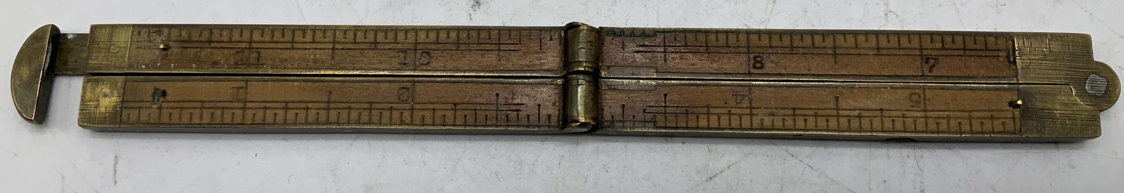 Antique Brass & Wood Folding Rule 12.5in: Antique brass & wood folding rule features joints, hooks & end caps. No visible signature or markings. Surface wear consistent to age, use & exposure. Measurements: length 12.5in x width 0.4in. Antiqu