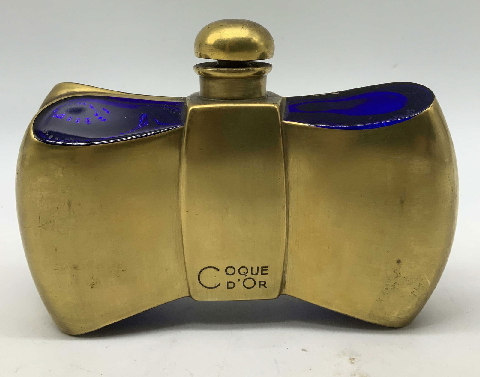 Vtg Guerlain Baccarat Coque Perfume Bttle FRANCE: Vintage Guerlain Coque d Or perfume bottle shaped like a bow tie. Features Baccarat cobalt blue crystal & gilt metal. Signed & marked on underside. Reads, GUERLAIN BACCARAT FRANCE COQUE D OR. Surface