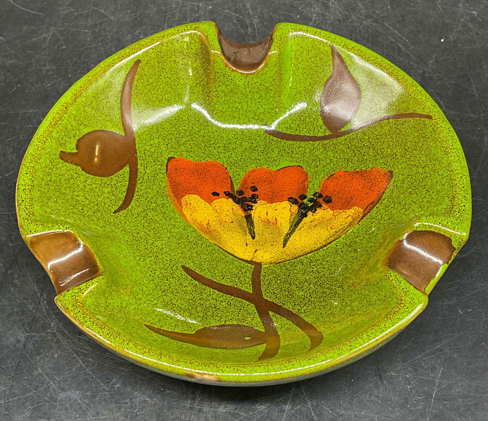 Vintage Green Flower Ceramic Ashtray, Italy: Vintage ceramic ashtray in green with floral motif, hand made in Italy. Measures approx. 7 x 1.75 inches. Some scratching. Ashtray, ceramic ashtray, floral ashtray, home decor, home accessories, table