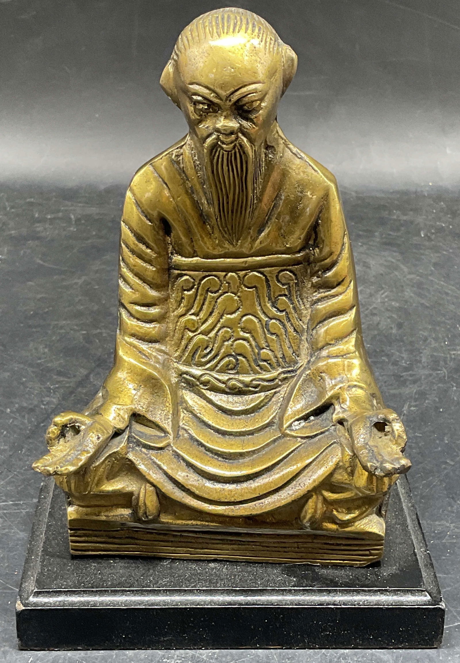 Vintage Asian Brass Immortal Figurine: Vintage Asian brass figurine on black base. Seated man, possibly an immortal figure. Measures approx. 5 x 3.5 x 7 inches. Piece has weight. Some scratching. Brass figurine, man figurine, immortal figu