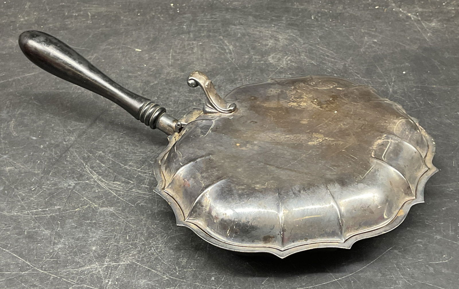 Vtg Chippendale Silver Plated Silent Butler: Vintage signed Chippendale style silver plated crumb catcher silent butler. Scalloped edge. Black wood handle. Measures approx. 10.5 x 7 x 2.5 inches. Wear including patina and scratching. Silent