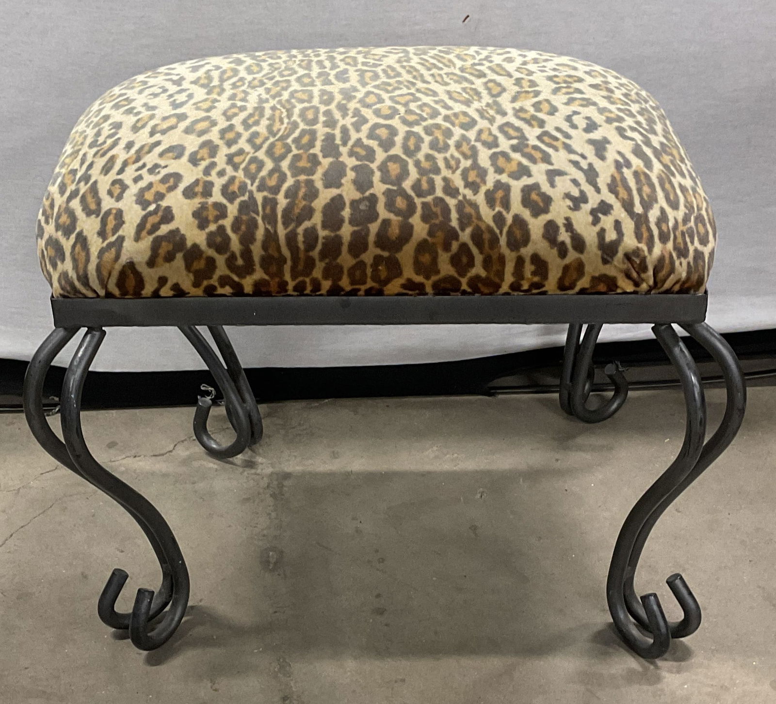 Trend Setting Designs Leopard Print Ottoman: Trend Setting Designs Metal scroll leg ottoman with leopard print upholstery. Measures approx. 18 x 15 x 13 inches. Some scratching and blemishes. Warping to one leg. Trend setting designs