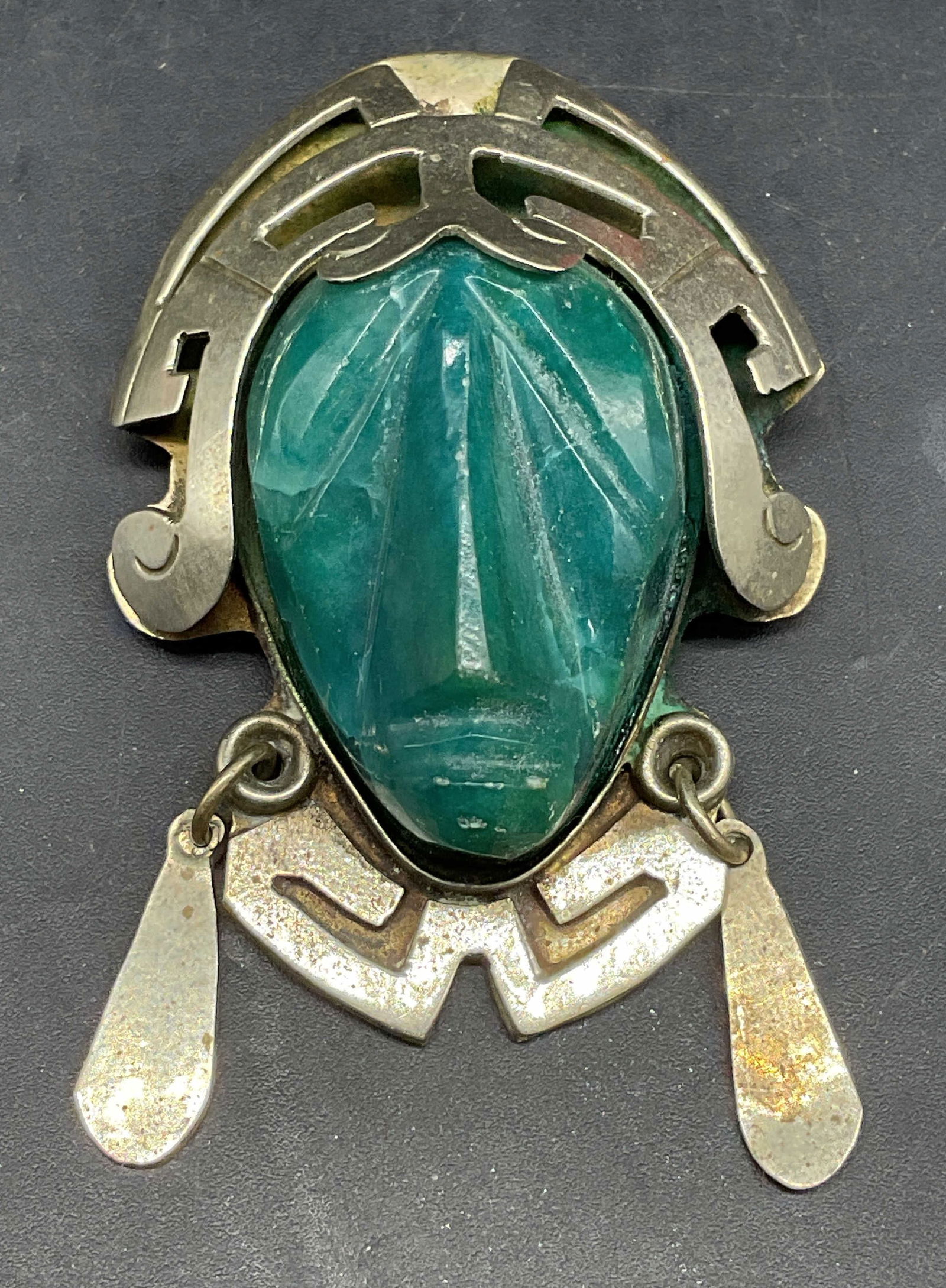 Vintage Silver Tone Semiprecious Aztec Brooch: Vintage handmade silver tone metal and carved green semiprecious stone Aztec warrior head pendant/brooch. Made in Mexico. Measures approx. 2.25 x 1.5 inches. Some scratching. Jewelry, estate