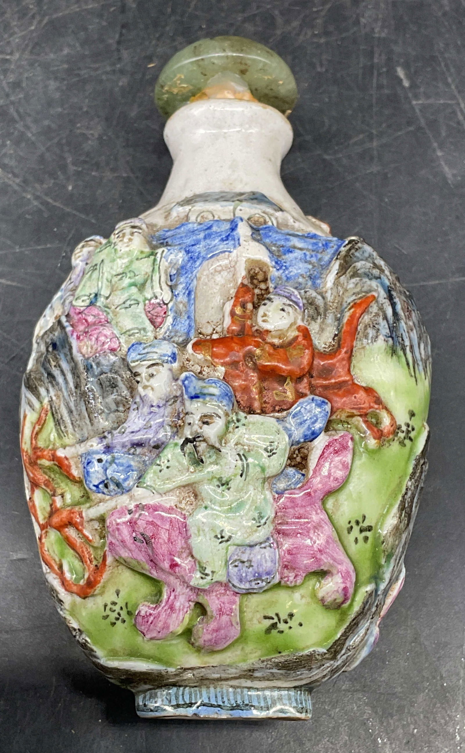 Vtg Signed Chinese Porcelain Snuff Bottle: Vintage signed Chinese molded porcelain snuff bottle. Raised traditional figural scenes. Jade lid. Hand painted. Interior not examined. Measures approx. 2 x 3 inches. Wear including scratching