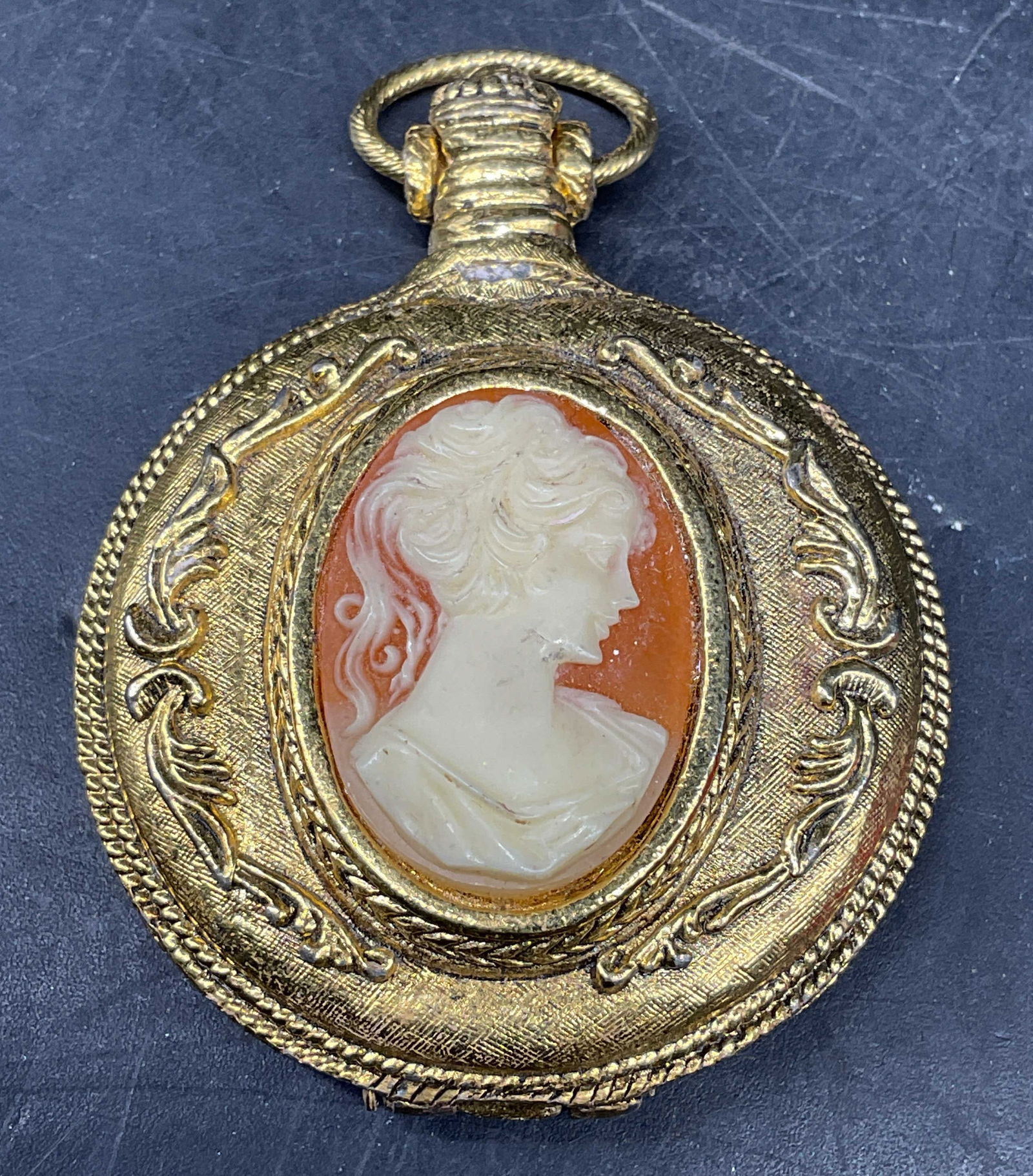 Vintage Max Factor Cameo Locket Compact: Vintage signed max Factor cameo locket powder compact. Mirror and powder on interior. Gold tone metal with faux shell cameo. Measures approx. 2 x 1.75 inches. Some scratching. Jewelry, estate jewelry,