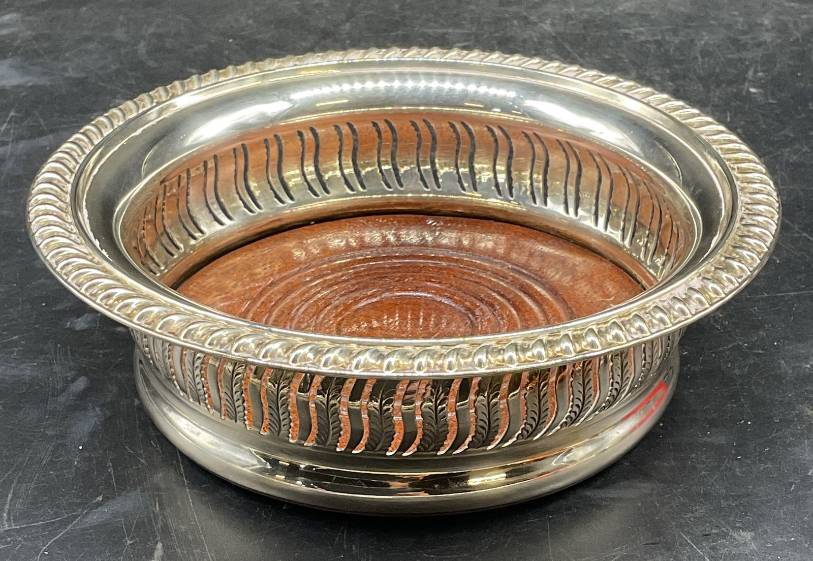 Vintage Silver Plated Pierced Wine Coaster: Vintage silver plated wine coaster with pierced design and wood base. Felted underside. Style of Barker Ellis, no signature observed. Measures approx. 5.75 x 1.75 inches. Some patina and scratching. W