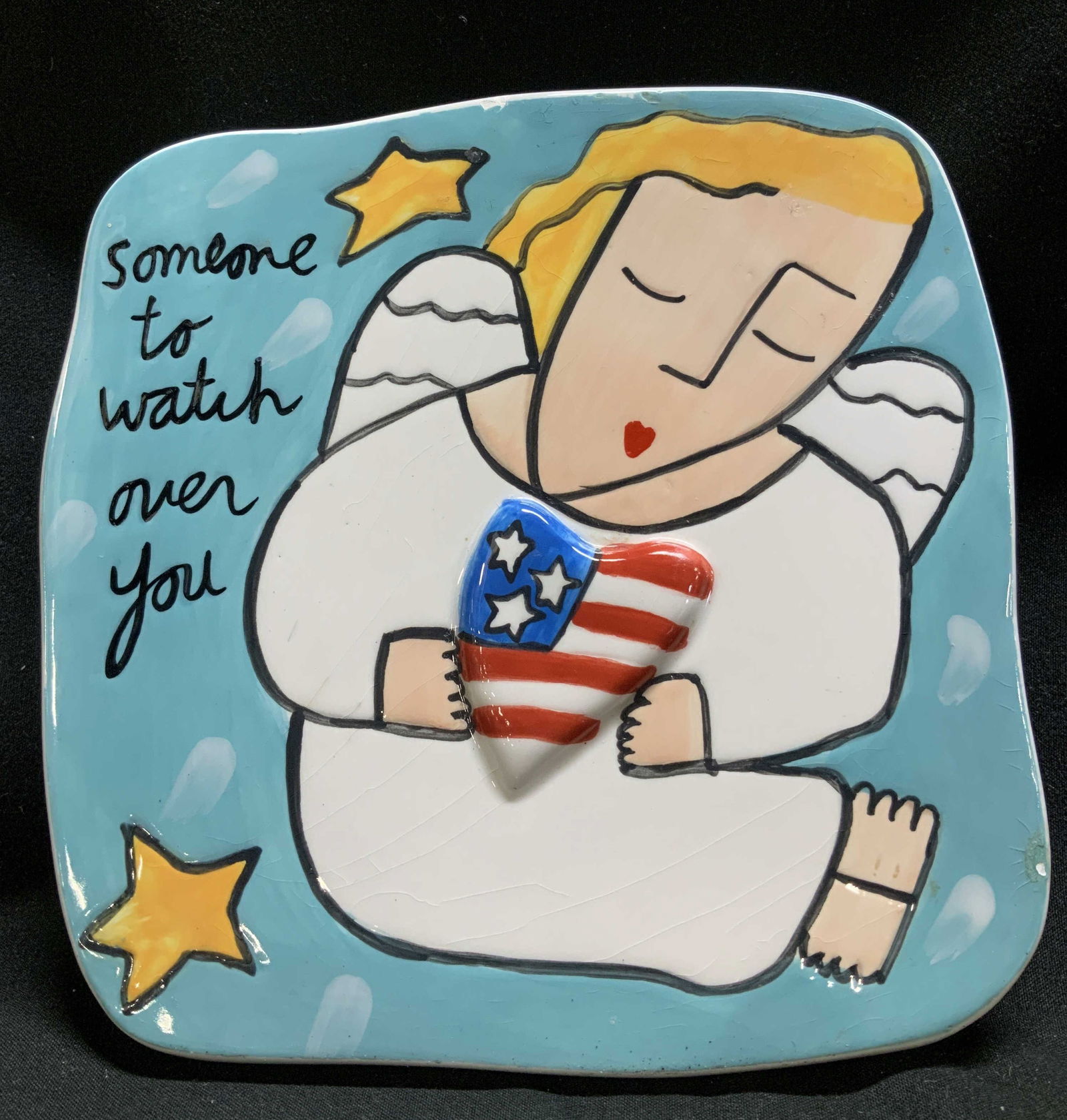 Sandra Magsamen Silvestri Patriotic Angel Plaque: Sandra Magsamen for Silvestri Someone to Watch Over You plaque featuring an angel holding a heart with an American flag design. Ceramic material. Signed & marked on underside. Reads, HANDCRAFTED FOR S
